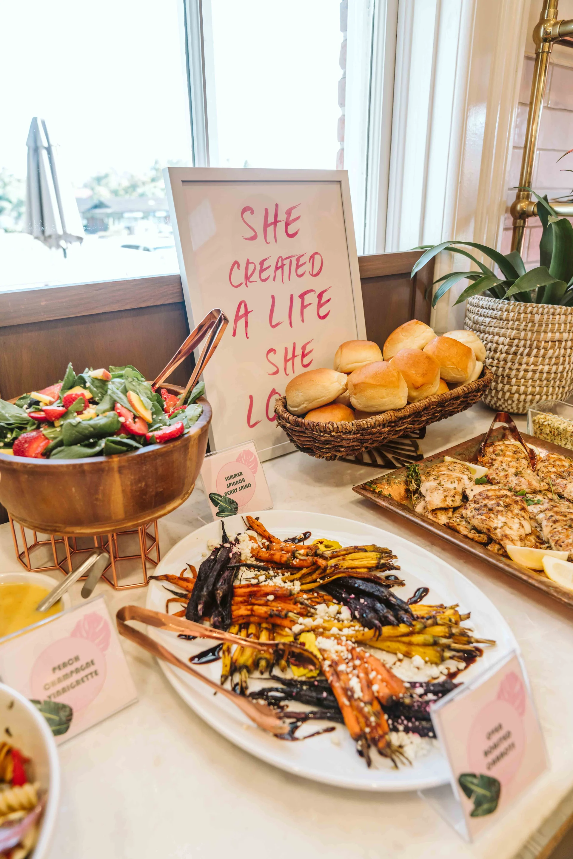 Dinner buffet beneath a sign reading “She created a life she loved”