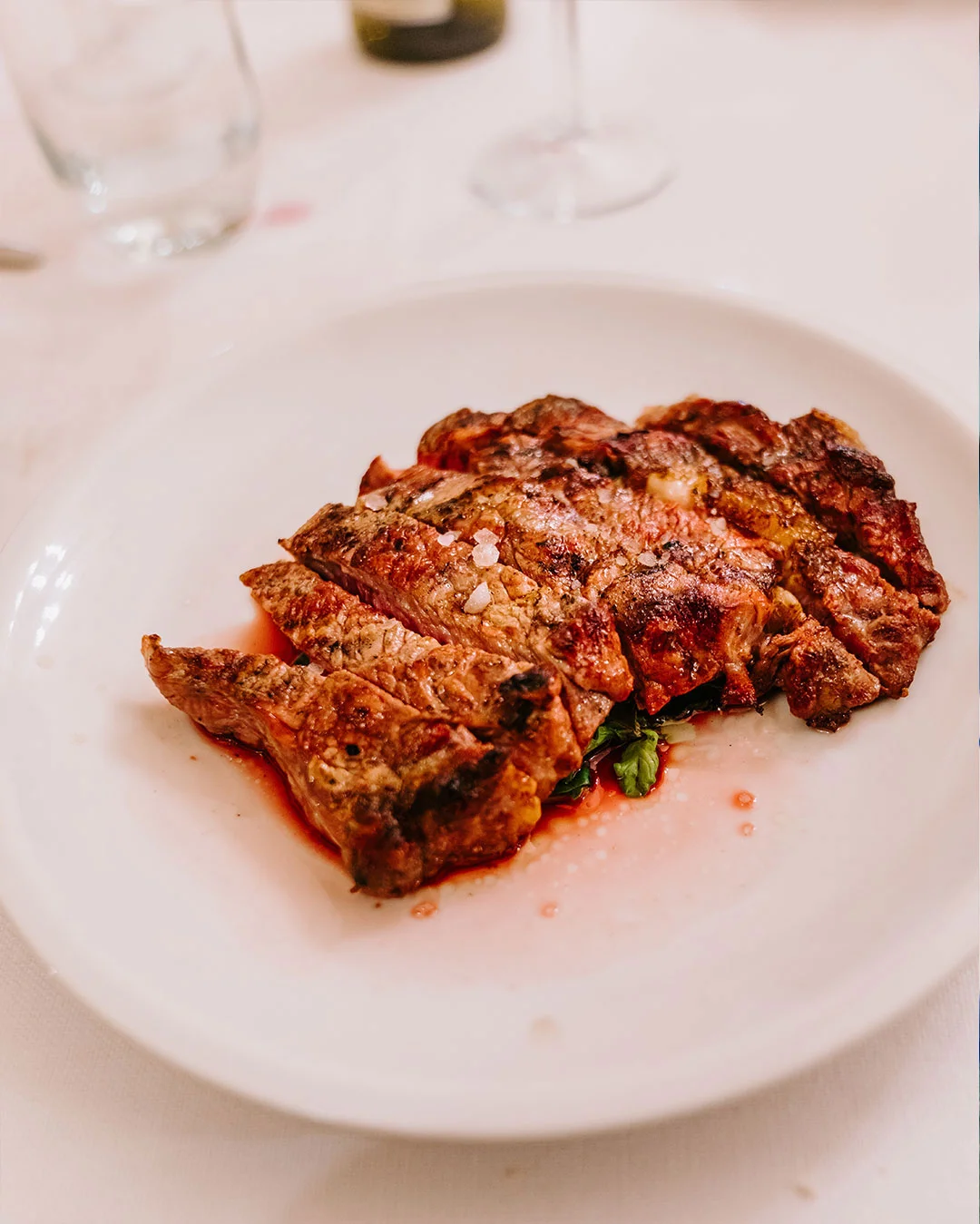 Sliced grilled steak served over greens