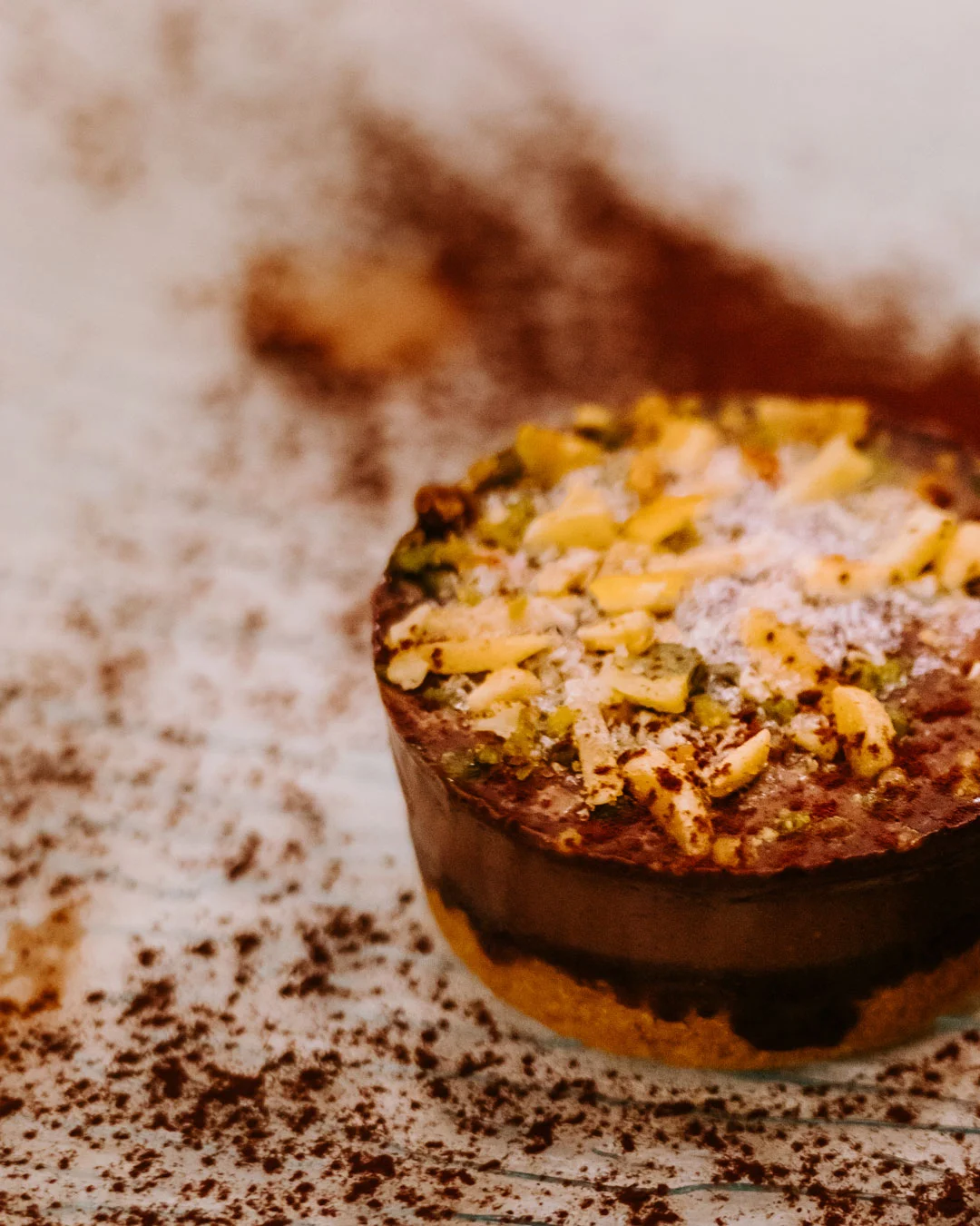 Round chocolate dessert topped with chopped nuts