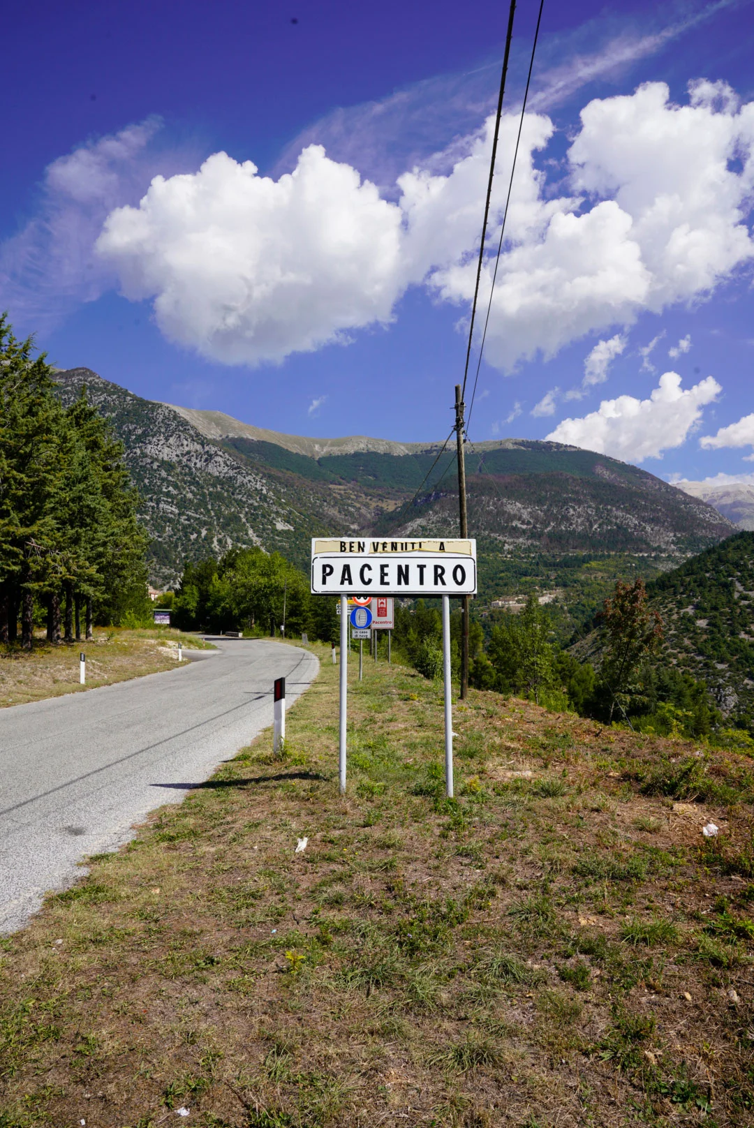 Pacentro welcome sign beneath a mountain ridge