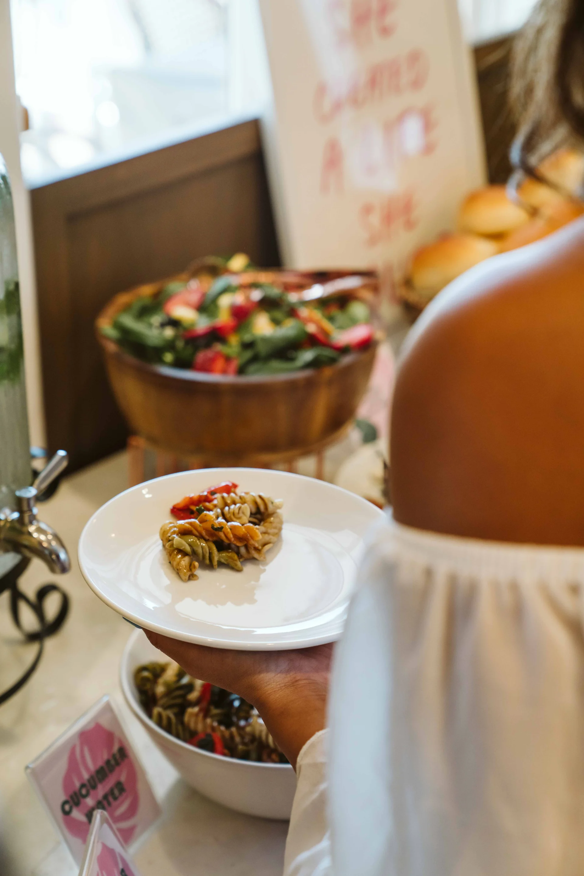 Guest carrying a plate of pasta from the buffet