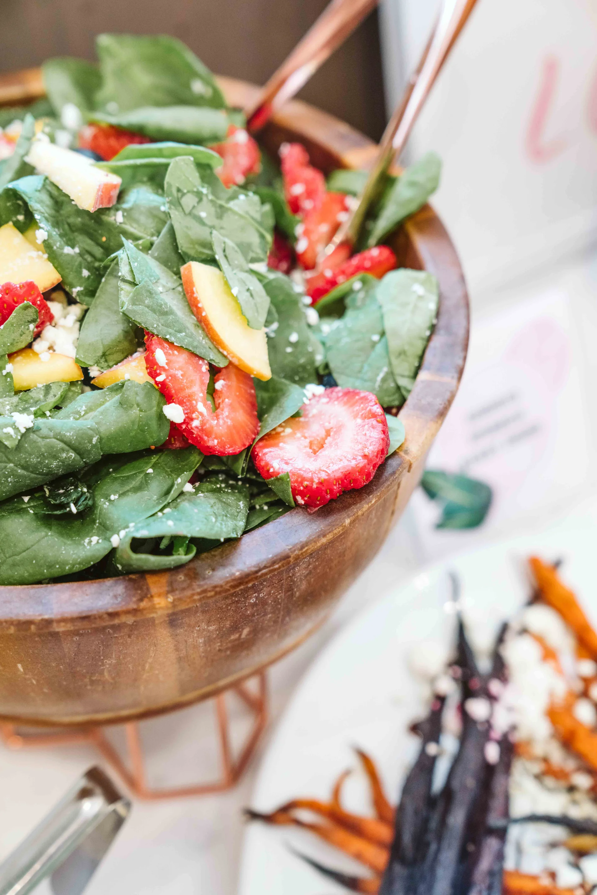 Spinach and berry salad in a copper serving bowl