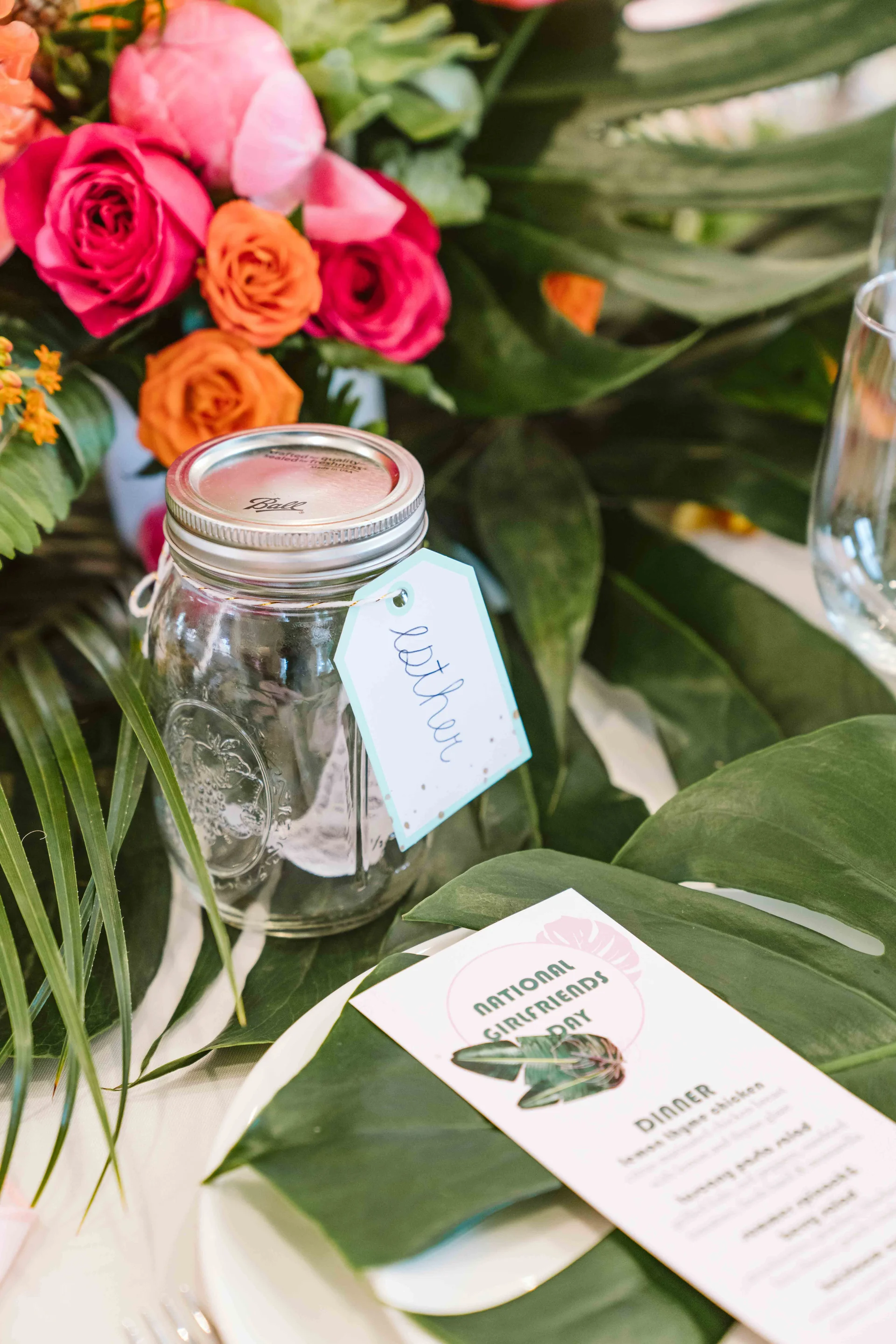 Affirmation jar beside a bright floral centerpiece