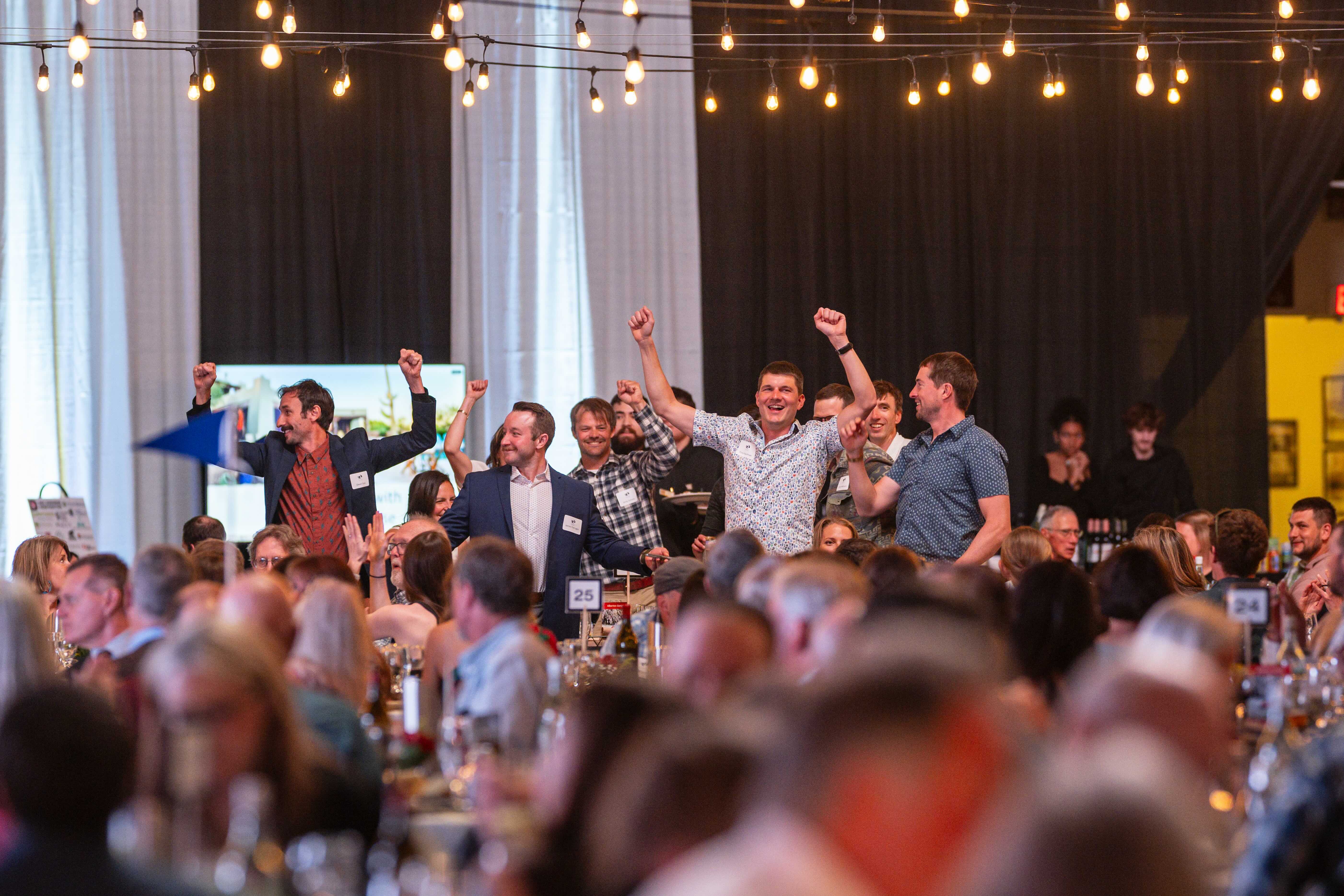 The seated crowd interacts with a live auction spotter at the 2023 Banquet, photo by Anastasia Wilde