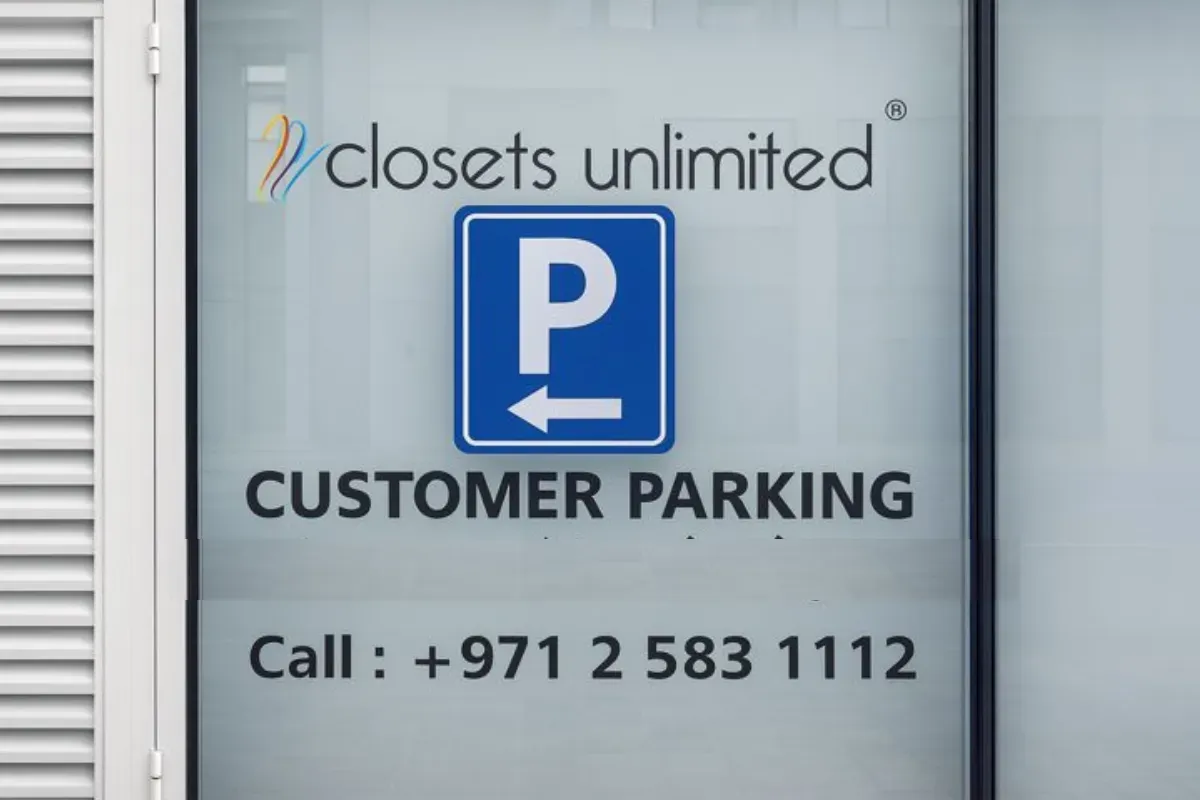 Storefront window lettering executed using solid white cut vinyl for directional and wayfinding purposes