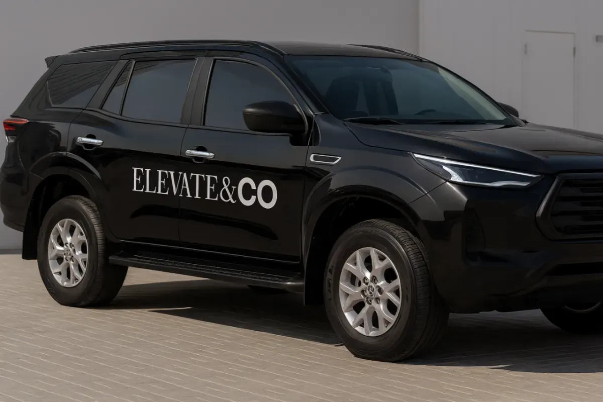 Company name lettering applied to vehicle sides using solid white vinyl for Elevate & Co fleet branding.