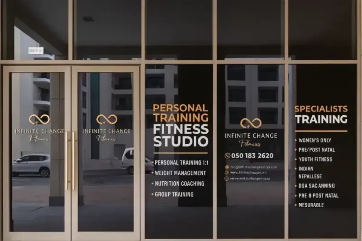 Infinite Change Fitness storefront privacy tinting with cut vinyl lettering displaying operating hours and service offerings for entrance visibility.