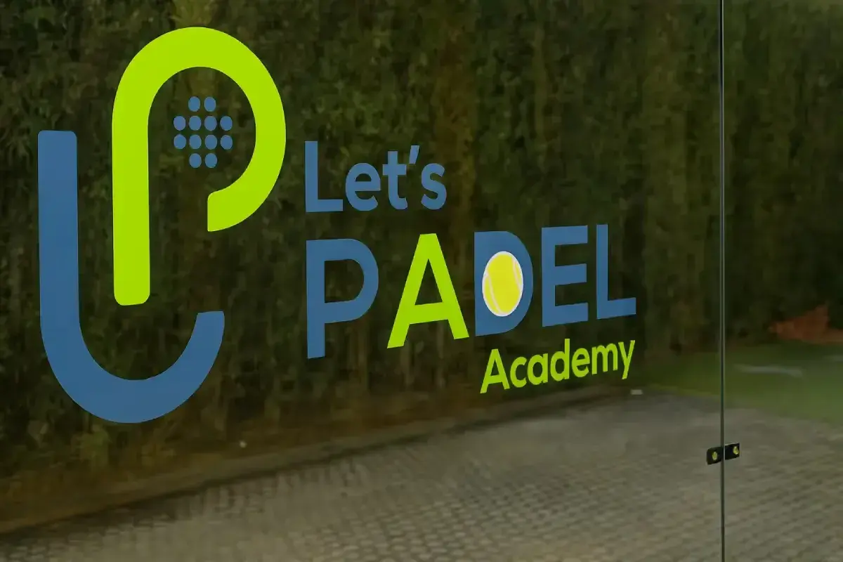 Cut vinyl logo lettering applied to padel court glass providing sports facility branding and player visibility during matches.