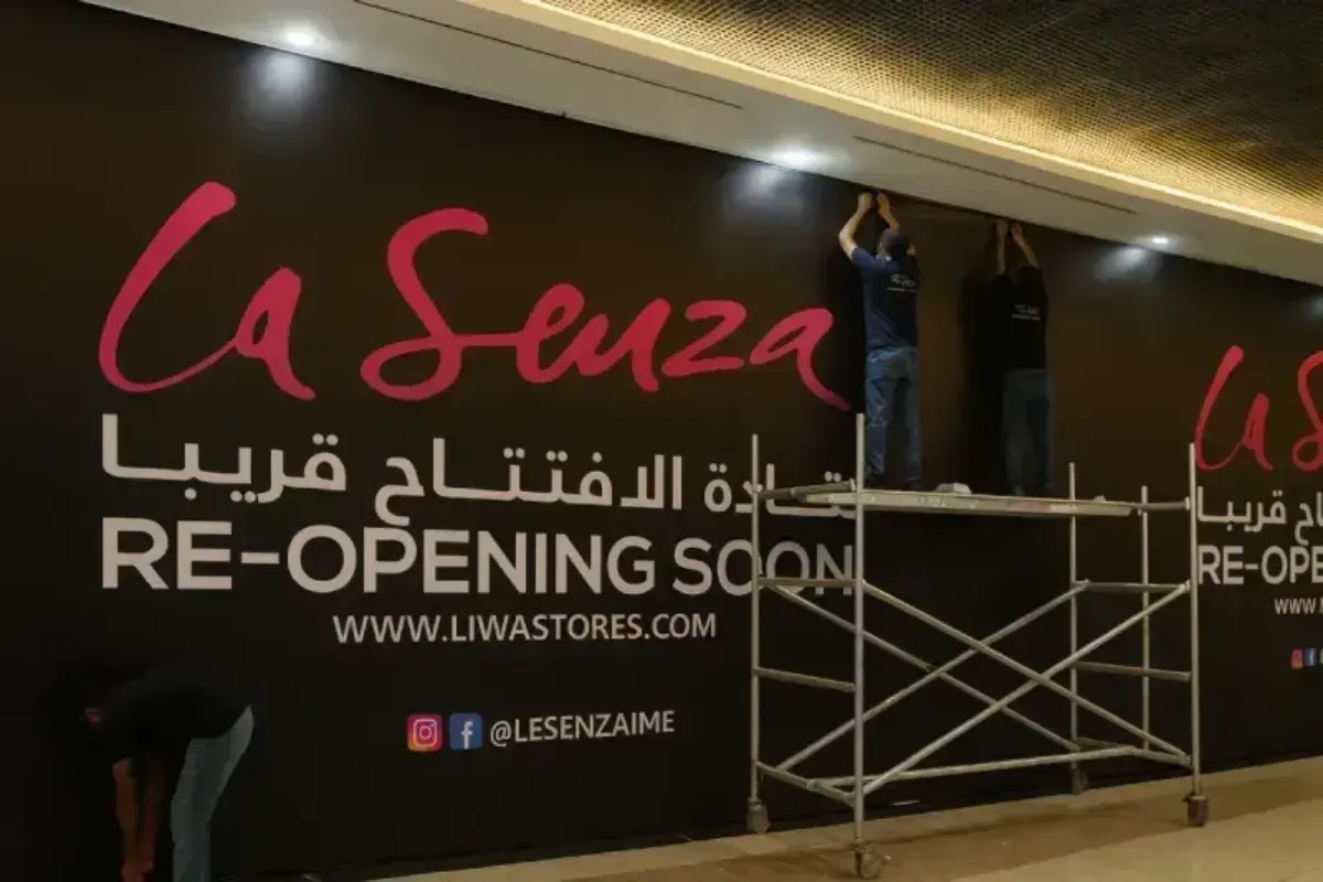 Large-format hoarding graphics providing visual screening during store renovation with branded mall-facing presentation.