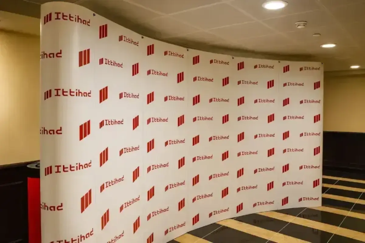 Curved exhibition system delivered for investment firm promotional activations, featuring large-format portable display with complementary branded counter for client engagement.