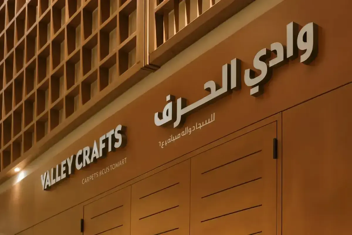 Dual-language stainless steel store signboard for furniture retailer featuring dimensional letterforms with precision hardware installation.