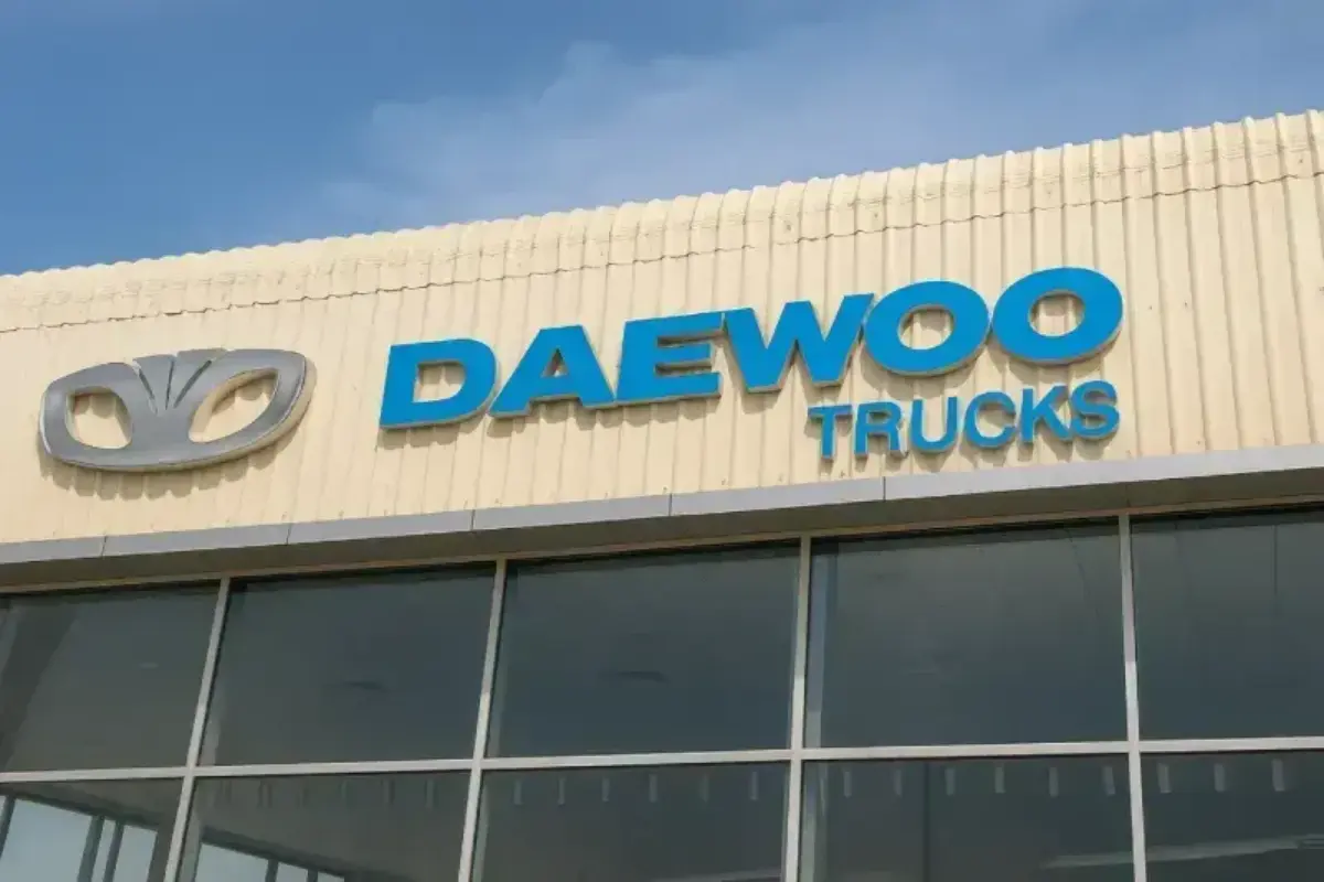 Frontlit aluminum building signage for automotive facility featuring dimensional letterforms with LED illumination on metal facade.