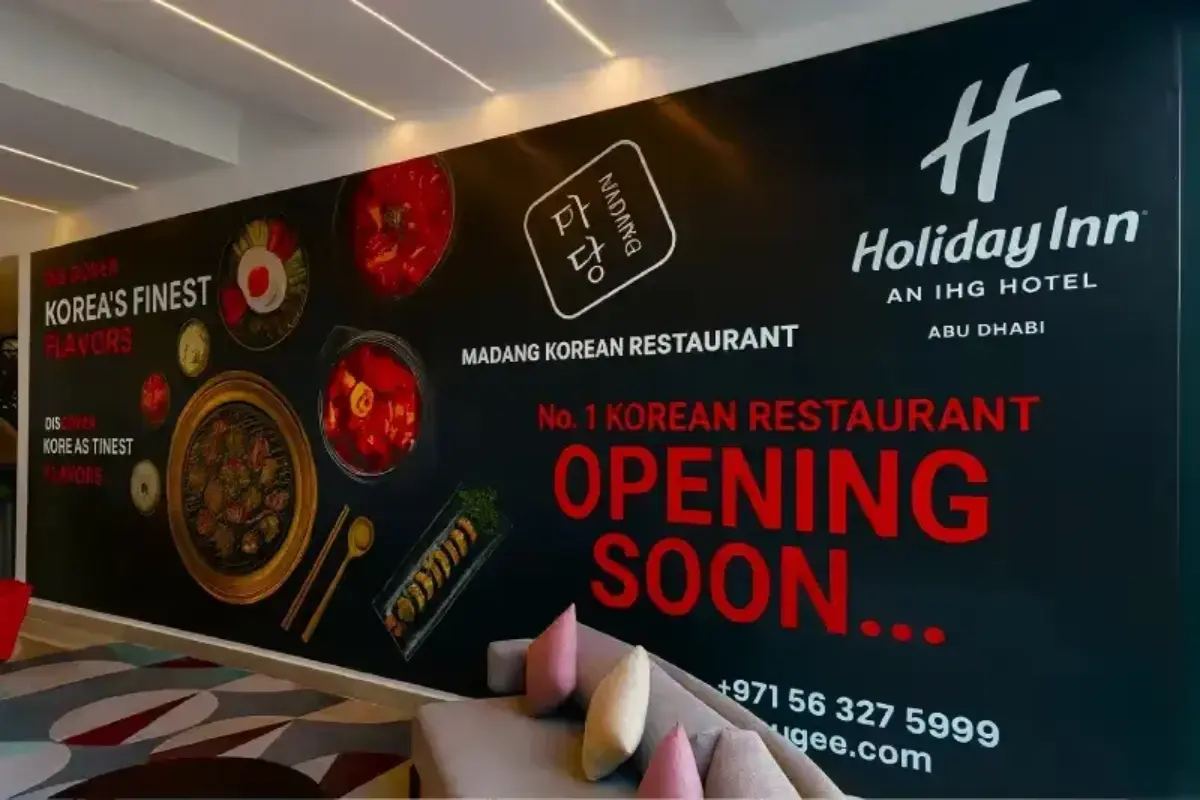 Indoor mall hoarding graphics with "Opening Soon" printed advertising graphics applied to existing Holiday Inn construction barriers during renovation period