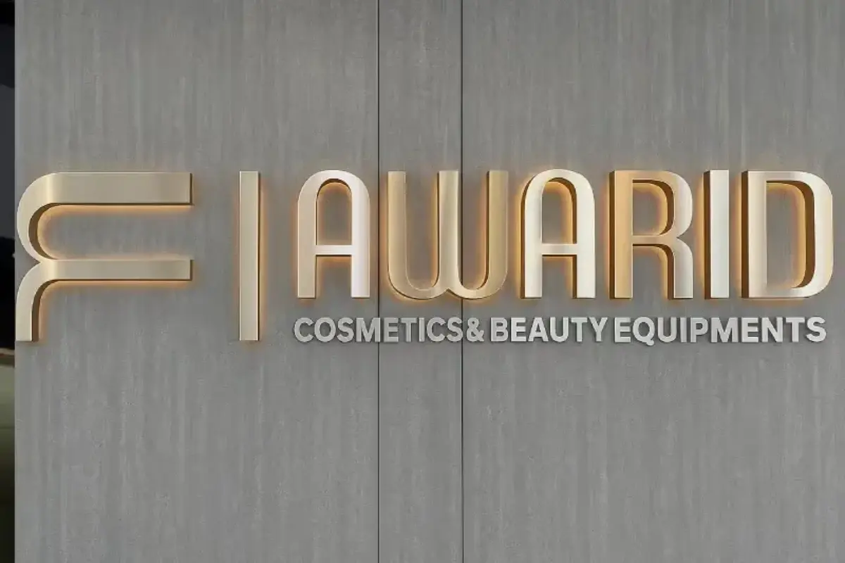 Brushed stainless steel dimensional letters with 10mm light-pass rear acrylic layer mounted on aluminum spacers for cosmetics retail reception area