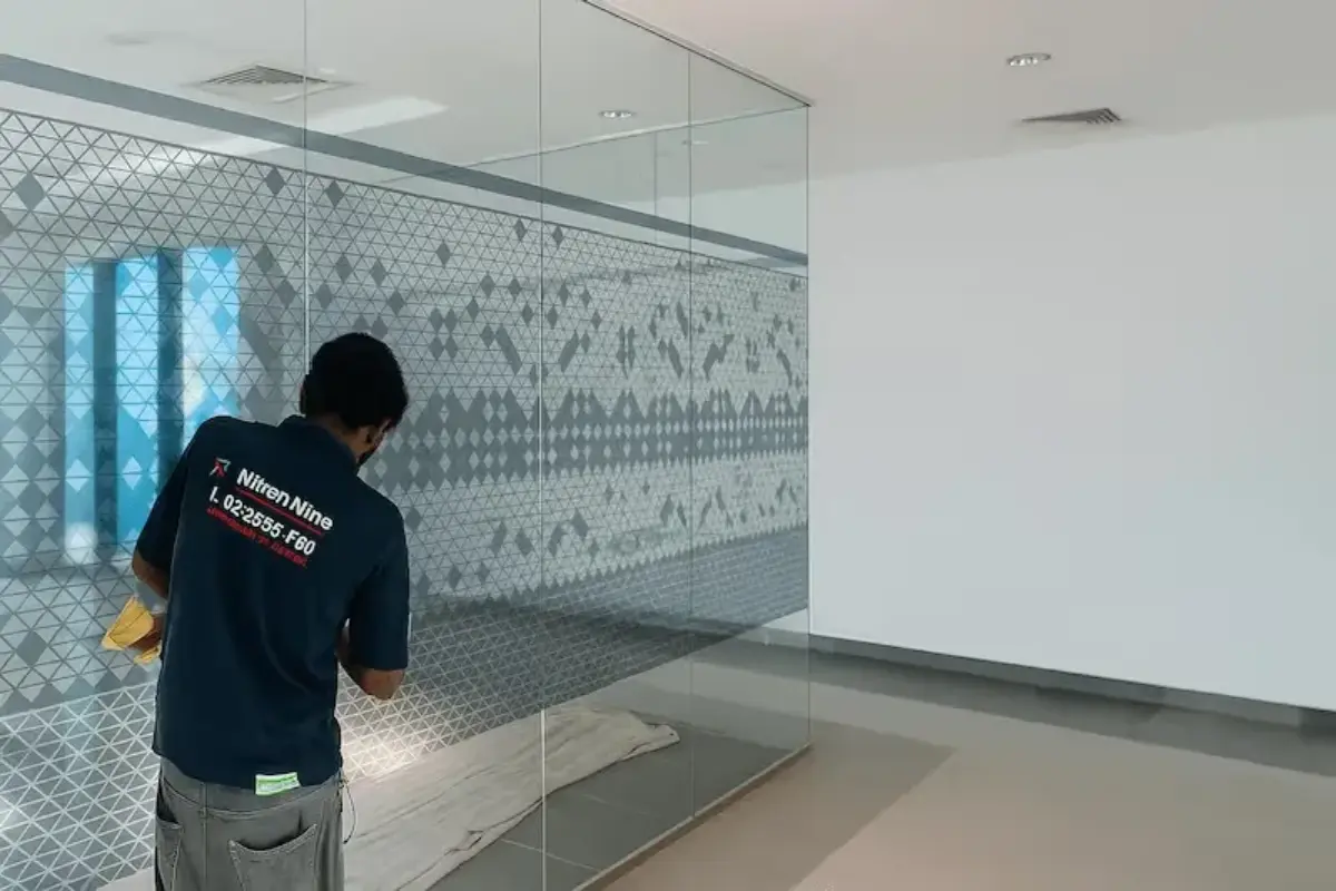 Ultra-clear transparent printed window graphics with client pattern across three floors totaling 600 square meters of coverage for Abu Dhabi Municipality facility.
