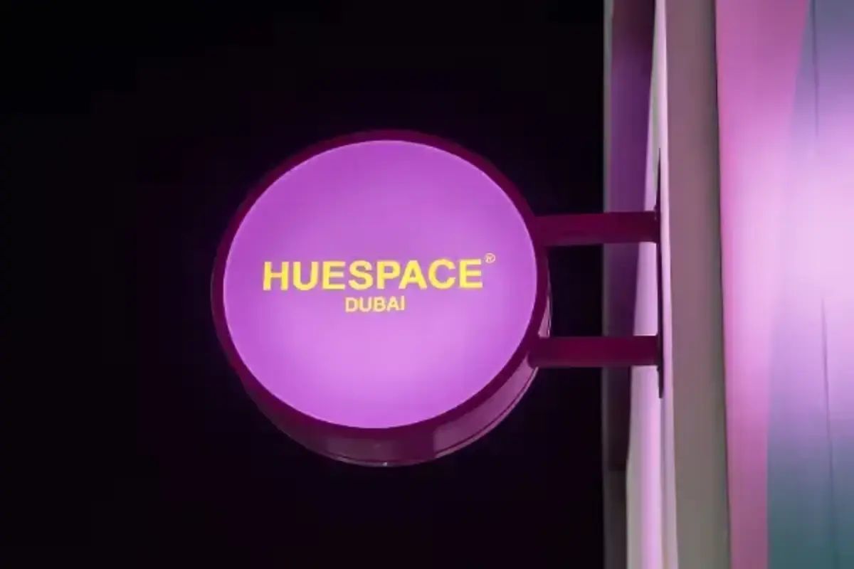 Low angle view of blade sign for Huespace pink illuminated circular logo Double Sided Blade Signs interior branding installation Dubai Ninety Nine Advertising LLC
