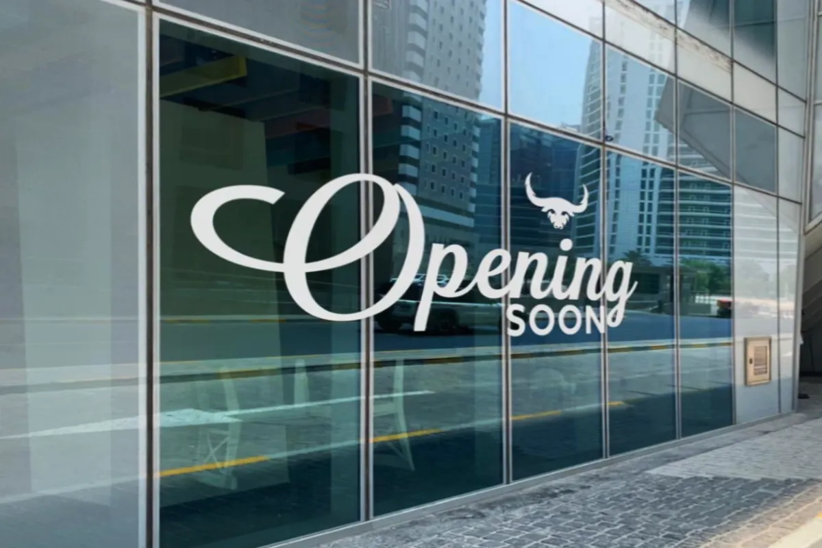 Side veiw shot of White Cutout Vinyl Lettering displaying "Window Cutout Vinyl Lettering" on a glass shopfront in Abu Dhabi by Ninety Nine Advertising LLC.