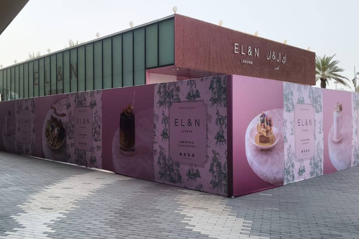 Full-width pink hoarding graphics featuring EL&N London drinks and dessert promotions