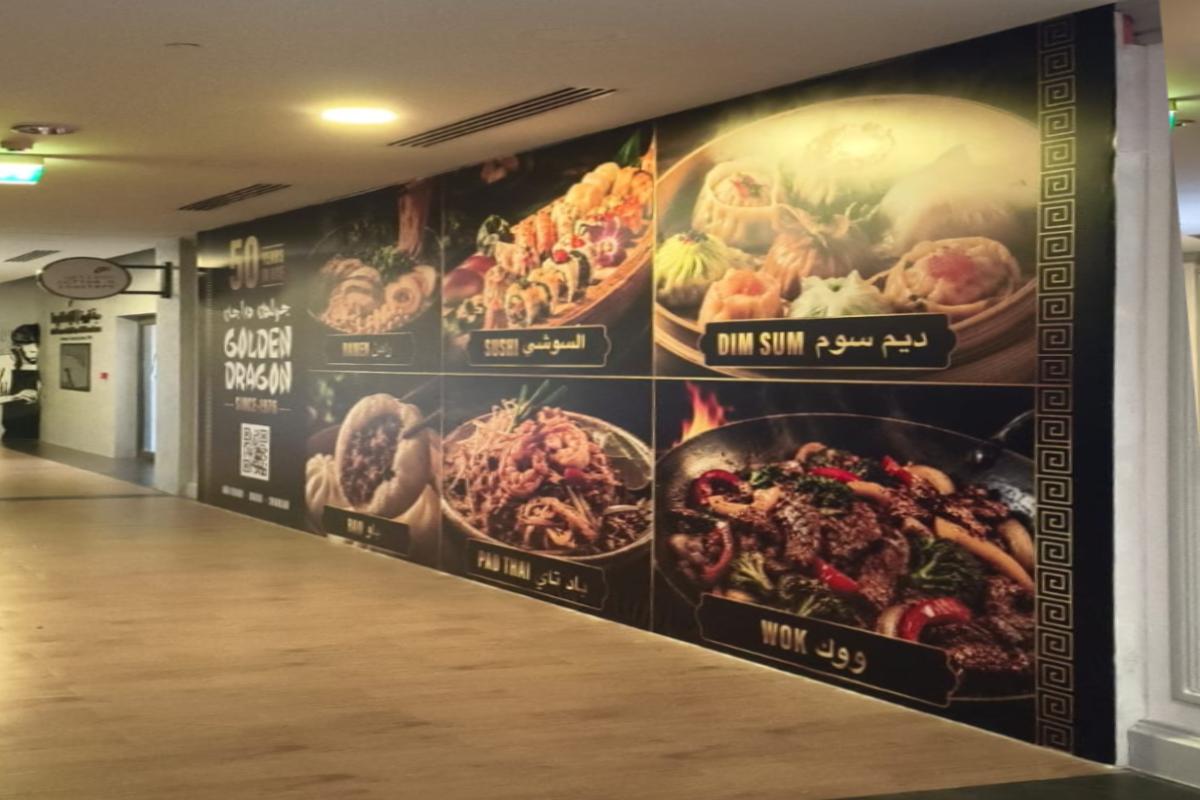 Large-format Hoarding Branding inside a UAE mall featuring high-resolution Asian food photography produced and installed by Ninety Nine Advertising LLC