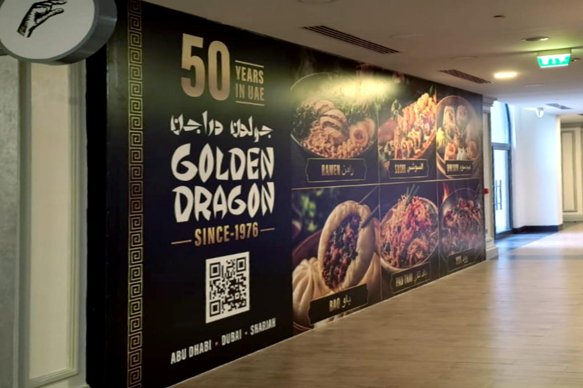 Premium interior Hoarding Branding for Golden Dragon restaurant showing 50th-anniversary branding and location details across UAE malls