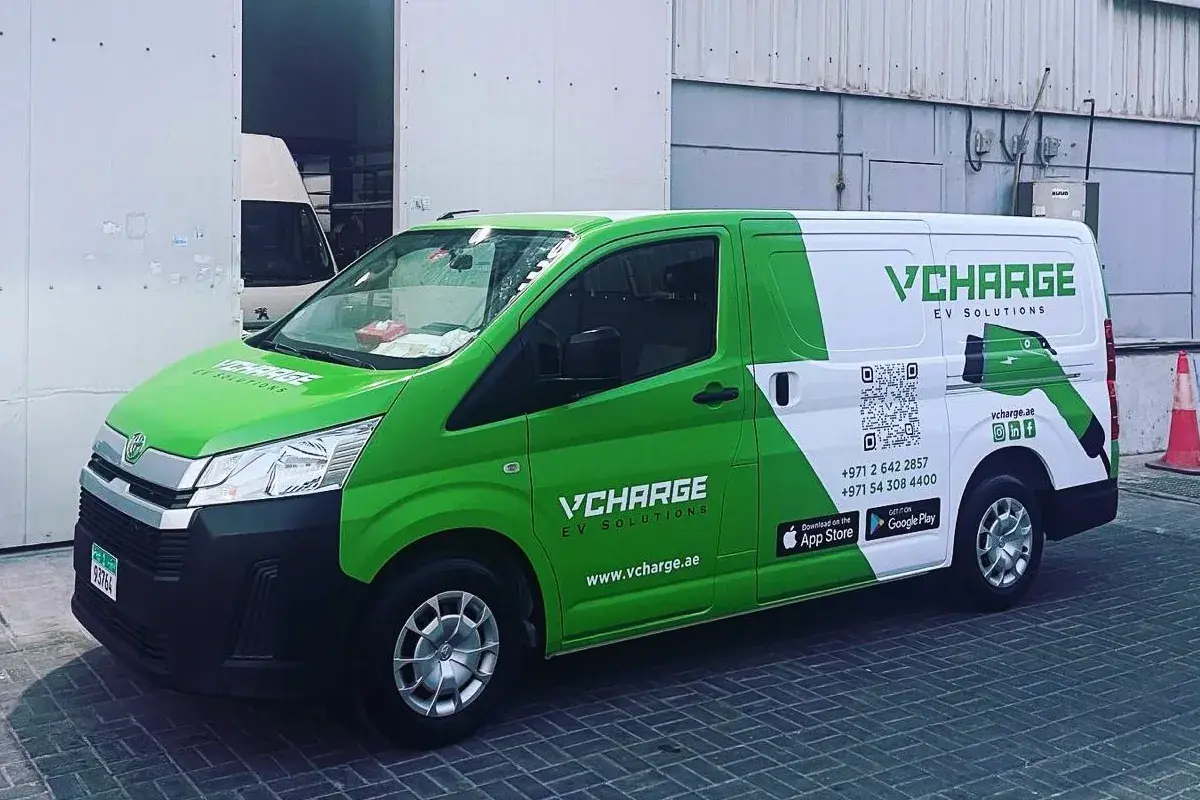 VCharge partial branding on a green Toyota HiAce in Abu Dhabi