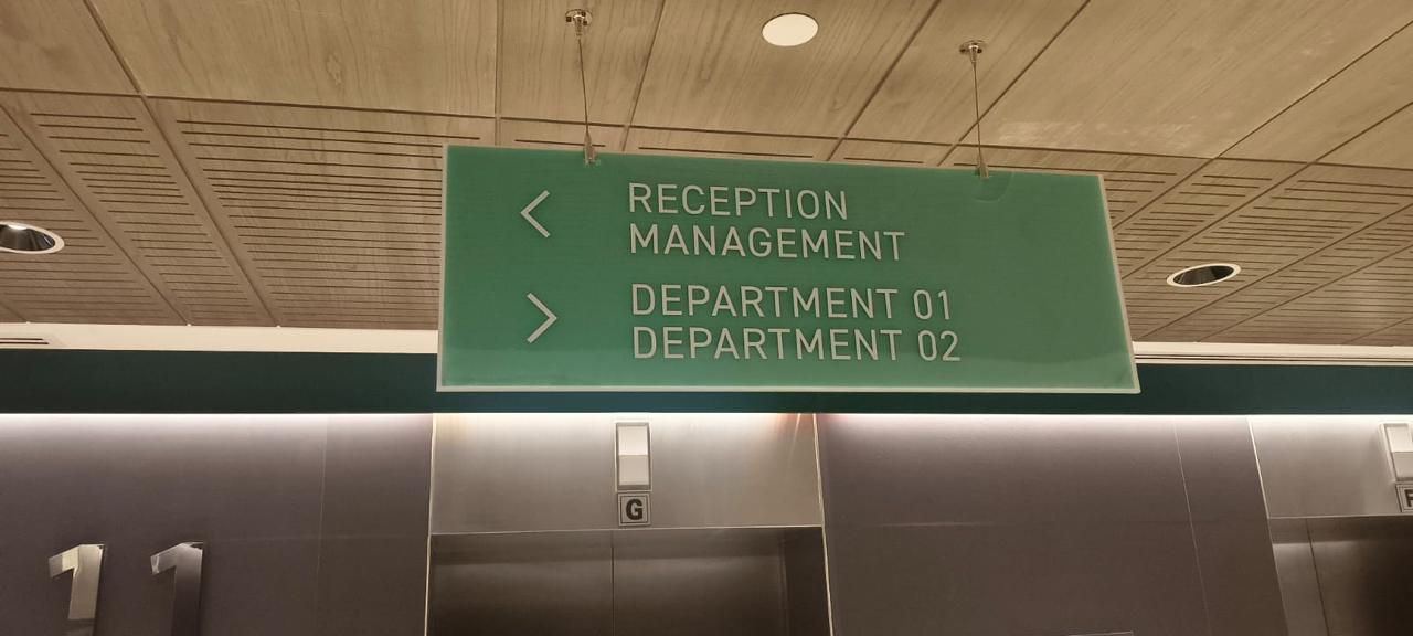 Green suspended direction sign for reception management and departments