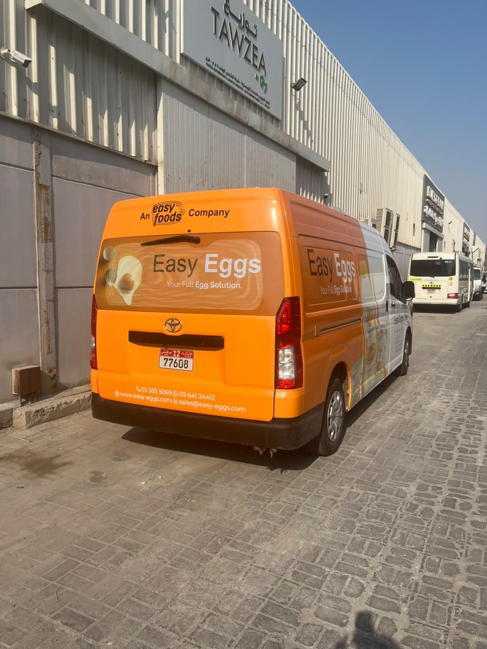 Rear three-quarter view of the orange Easy Eggs branded van