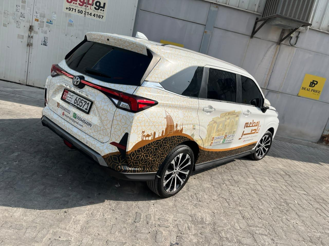 Rear three-quarter view of Nasser Restaurant vehicle graphics on a white Toyota