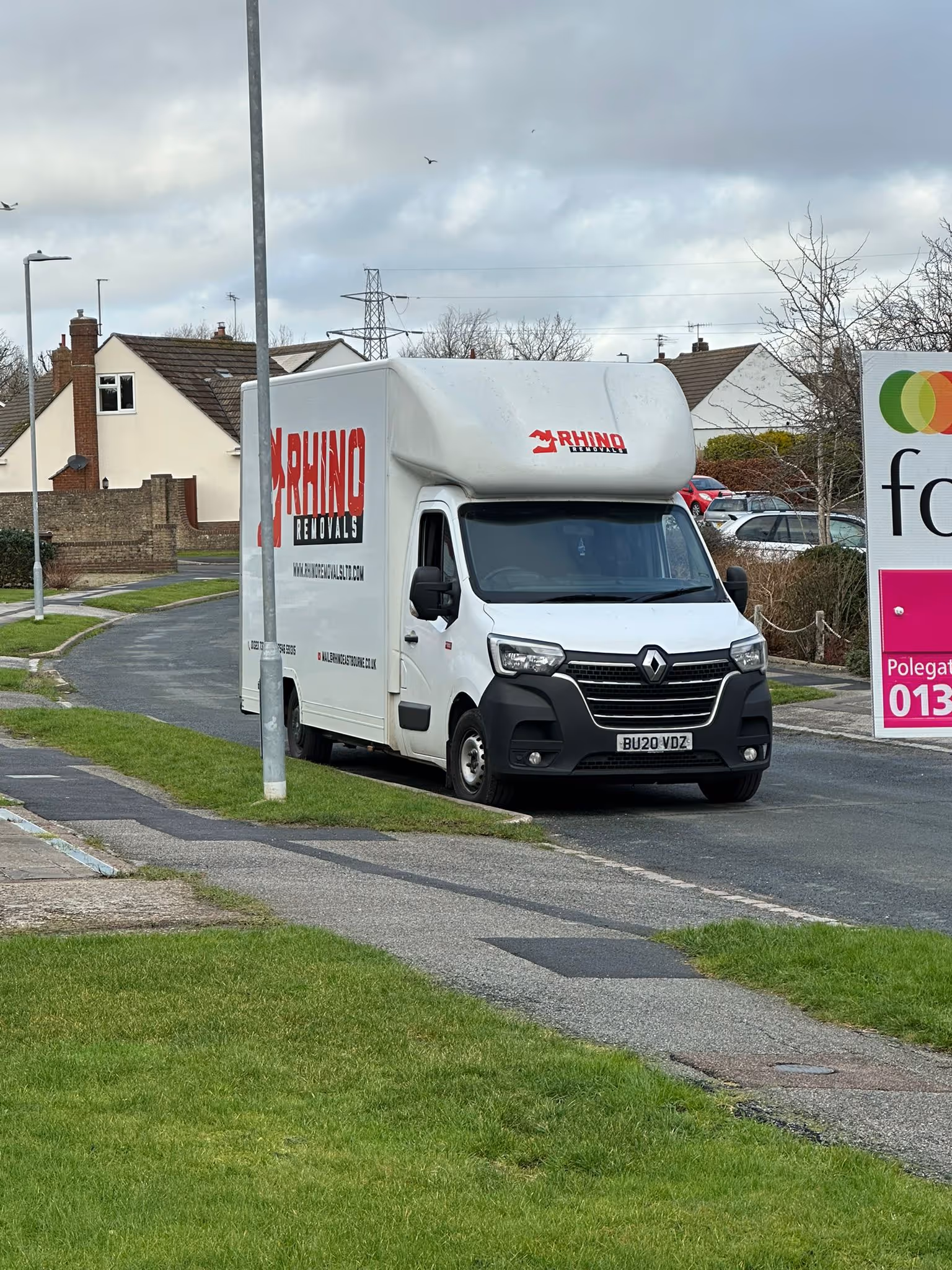 White removal truck labeled "Rhino Removals" parked on a residential street.