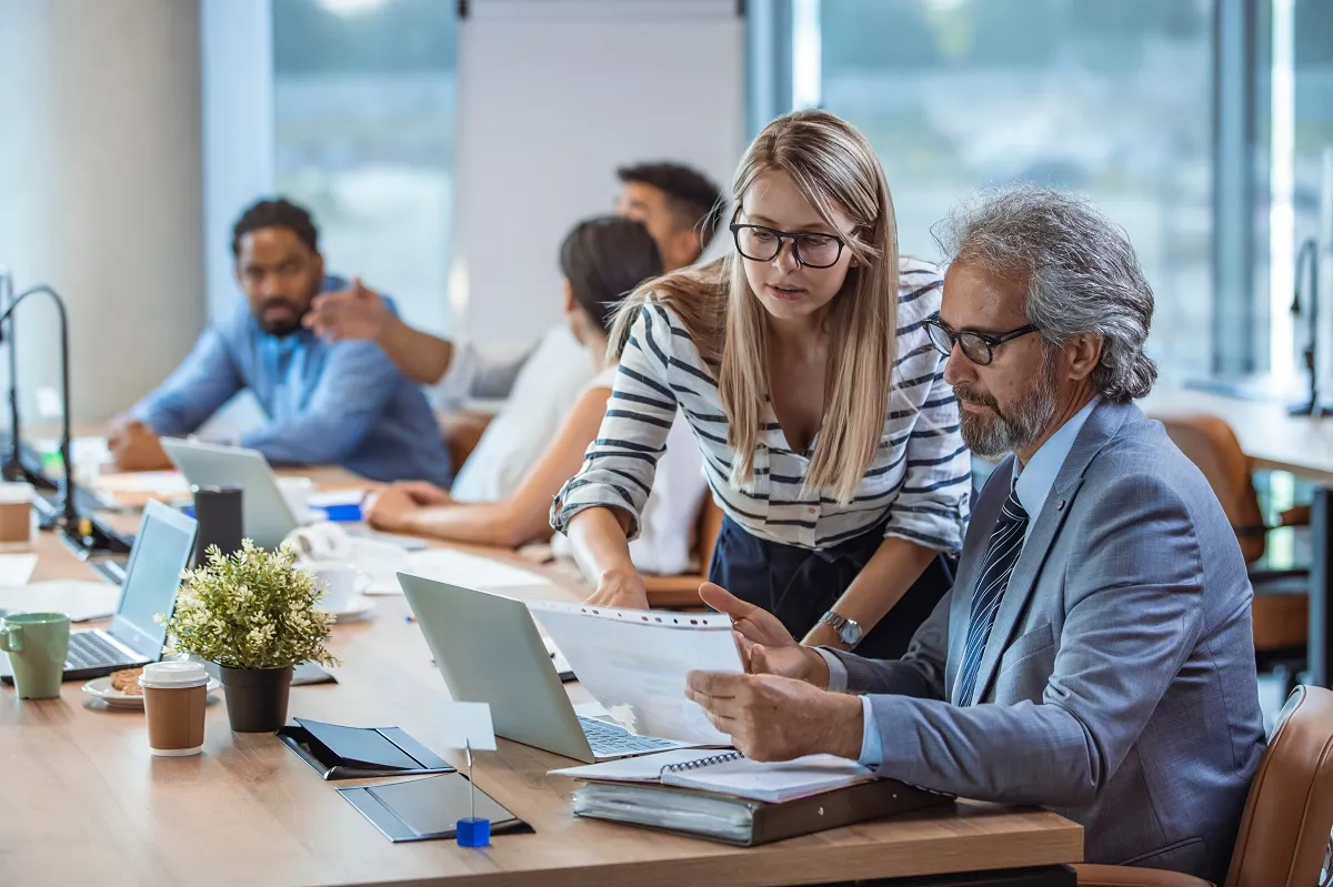 Business leaders discussing a report in an open office space