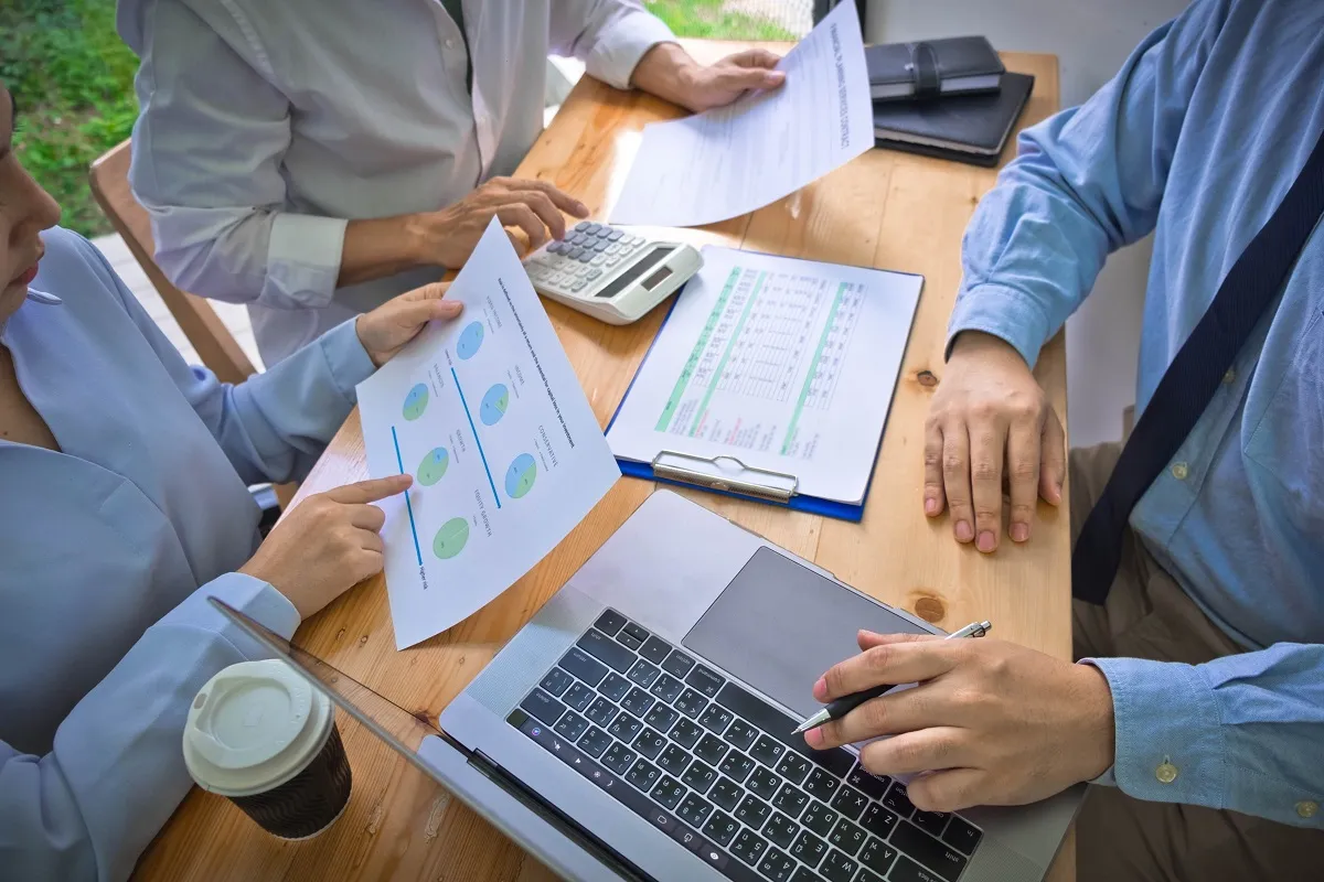 Meeting with laptop, calculator, and documents
