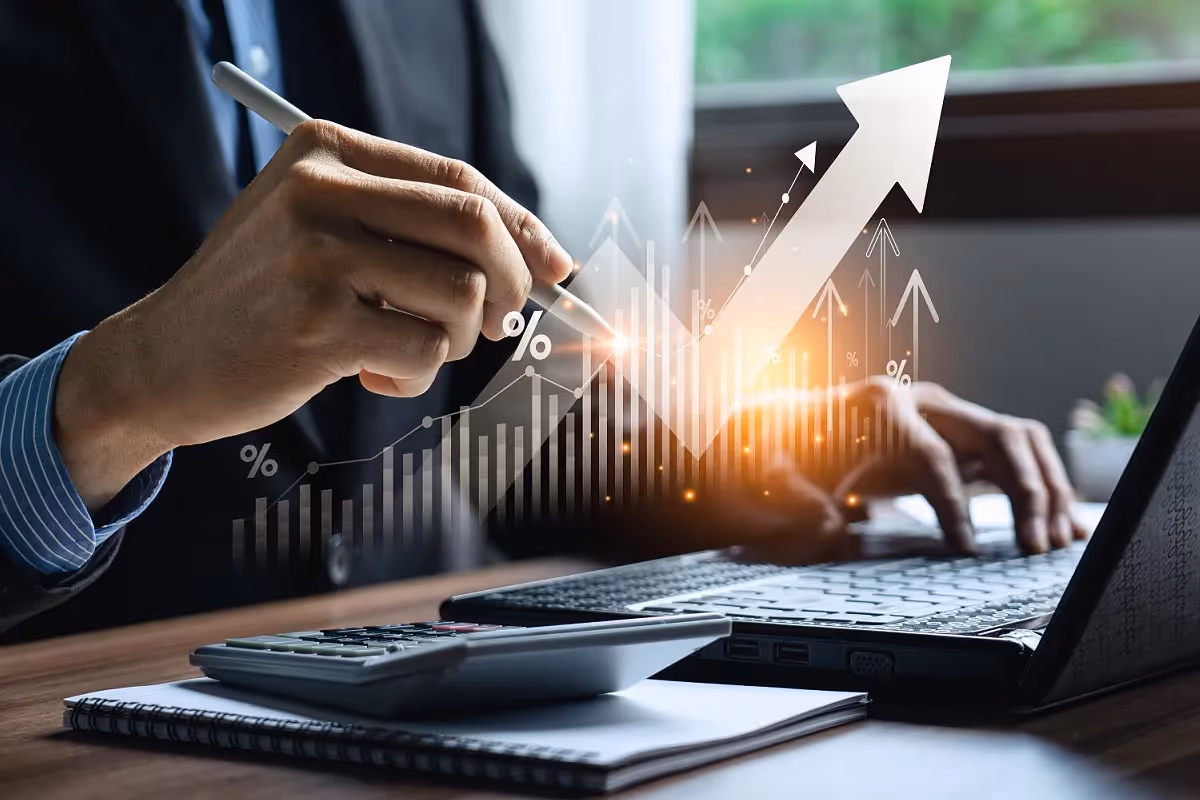Accountant working on a laptop with a graphic overlay representing economic growth