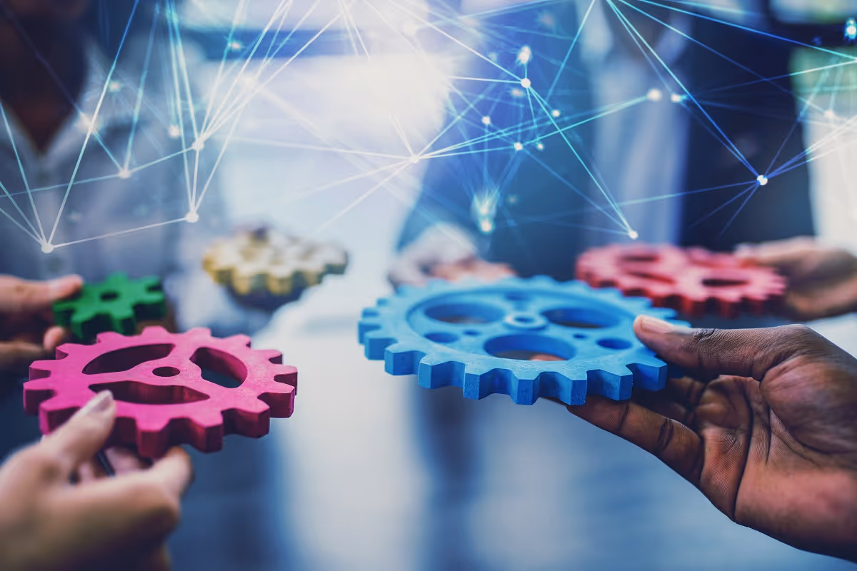 Close-up of hands holding colorful interlocking gears, symbolizing AI used in corporate roll-ups