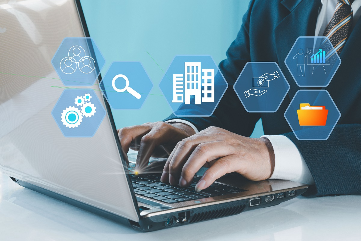 Businessperson typing on a laptop with floating icons for company structure, compliance, and financial analysis, representing virtual data room and digital due diligence tools