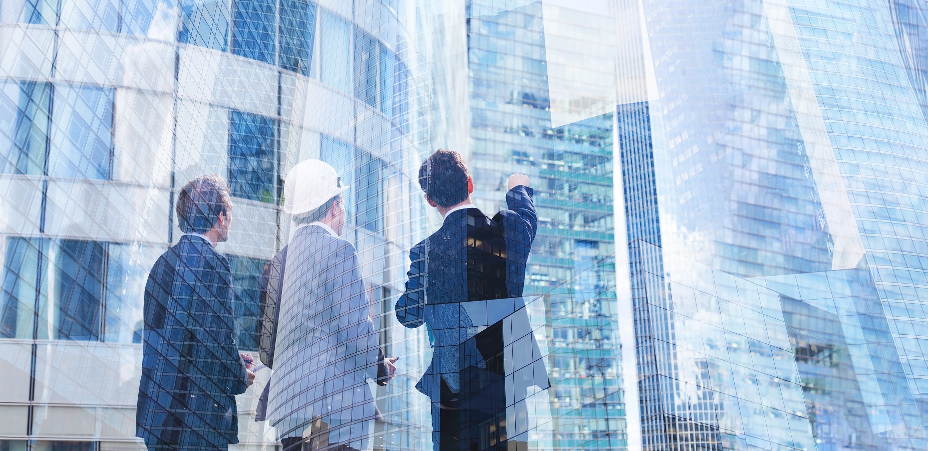 Business leaders and an engineer reviewing modern commercial buildings, symbolizing investment and corporate development