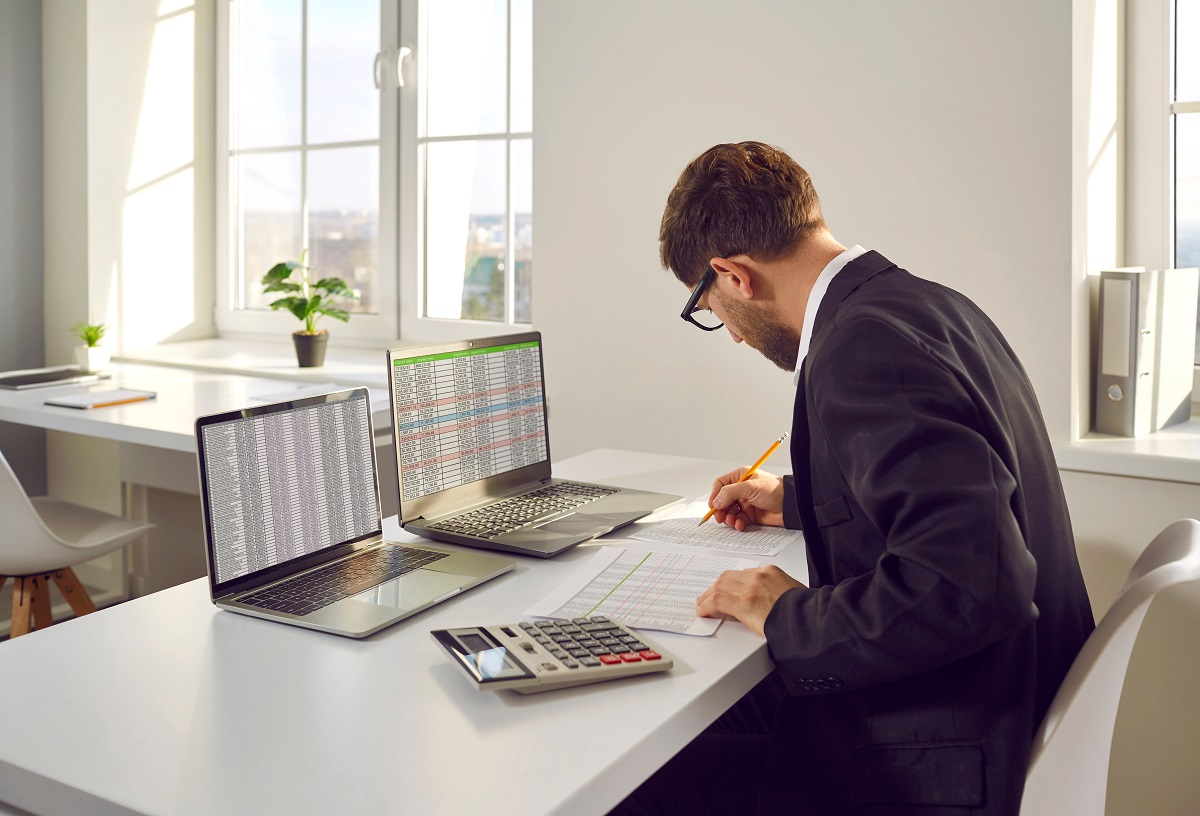 Financial analyst reviewing spreadsheets and cash flow data during financial due diligence for a merger or acquisition