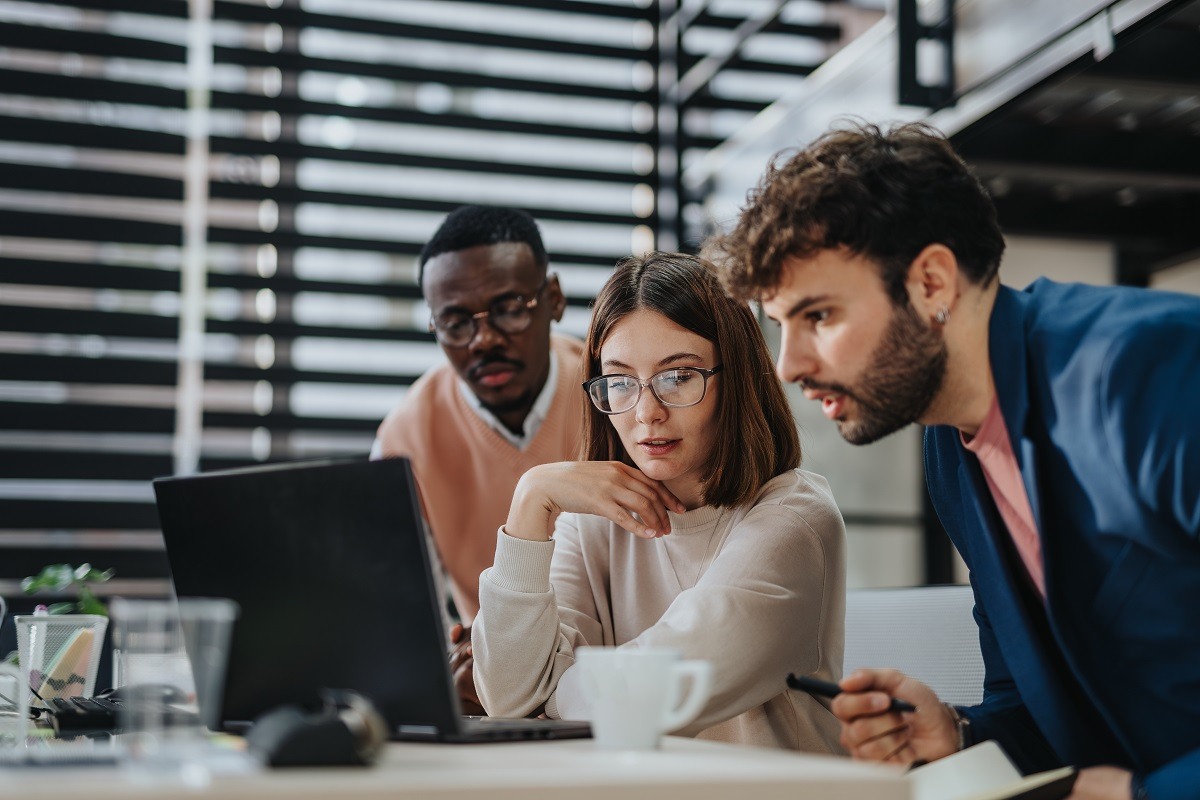 Legal and compliance team reviewing vendor documents and risk data on a laptop during due diligence evaluation
