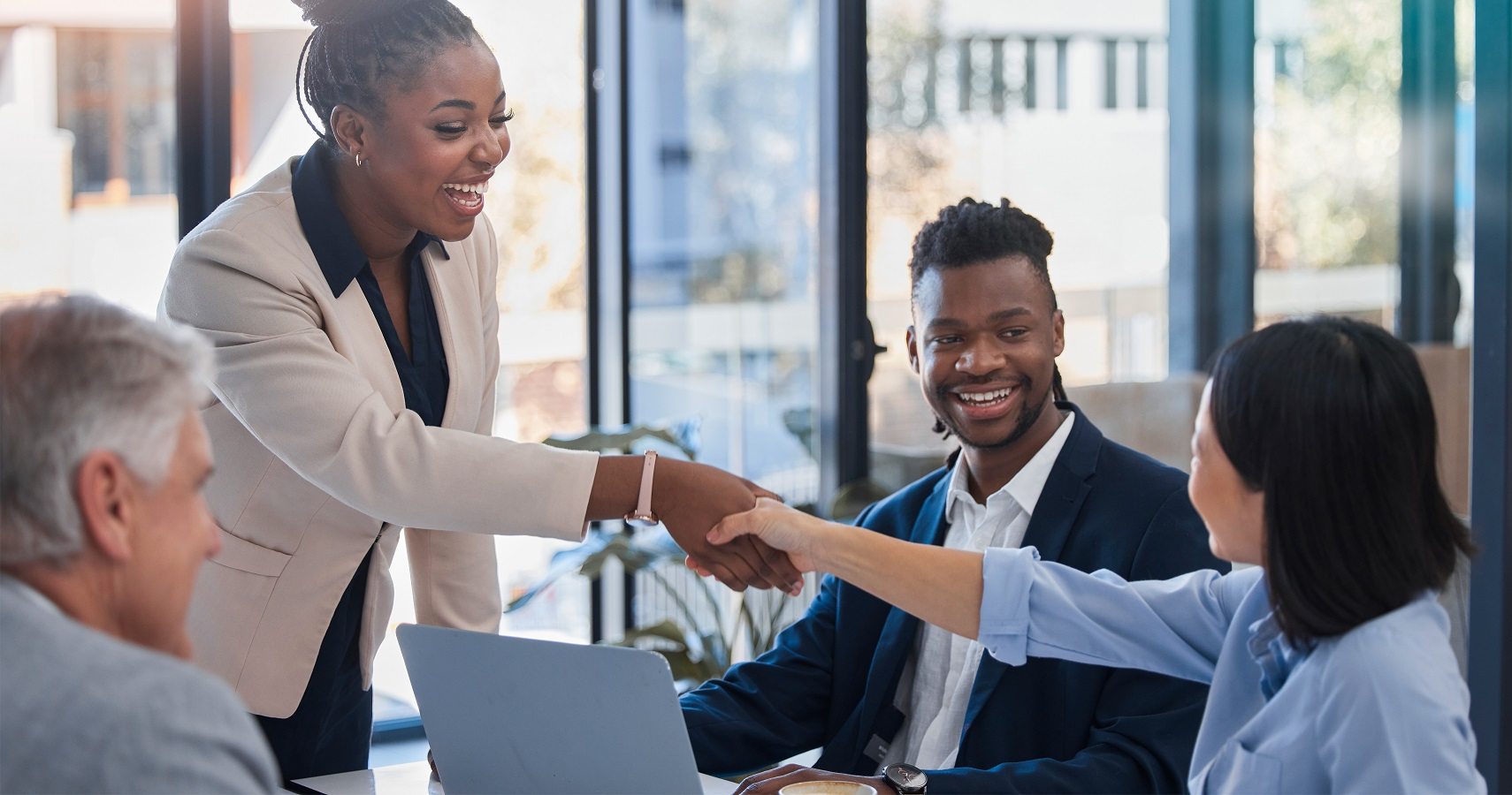 Business partners shaking hands during merger or acquisition meeting