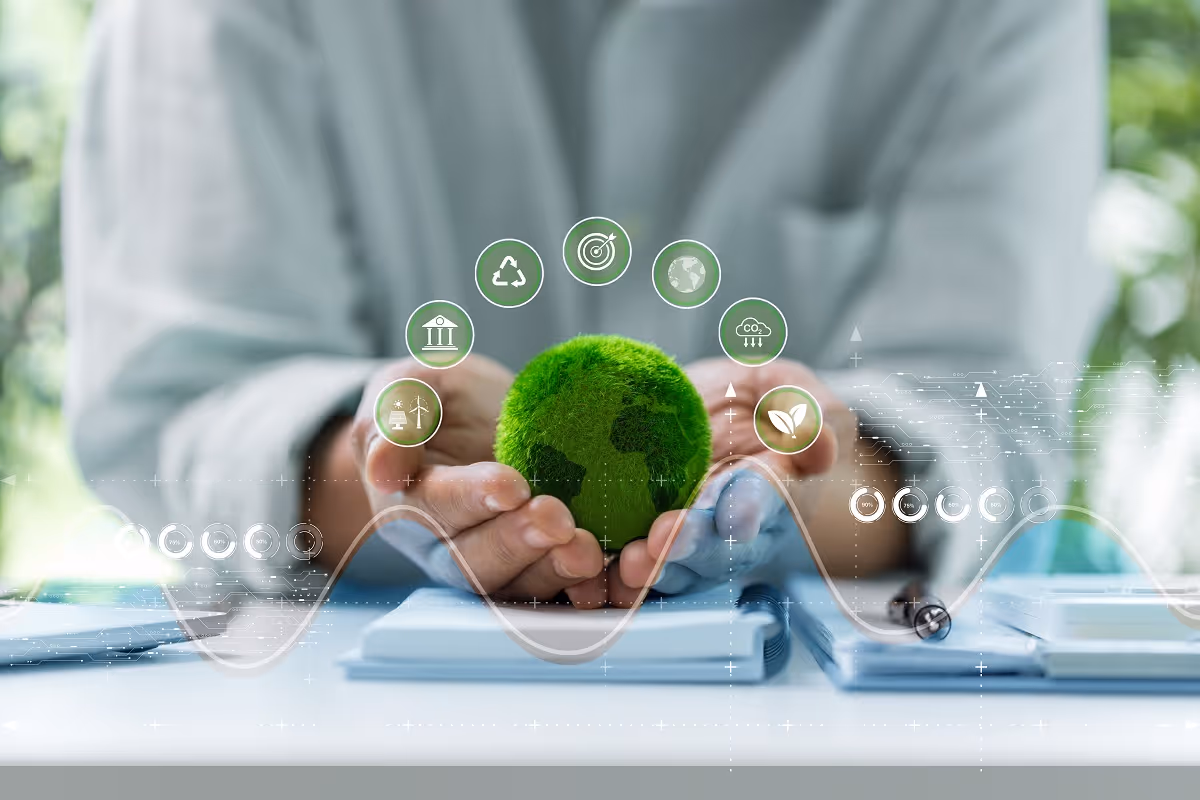 Hands holding a green globe symbolizing environmental compliance and sustainability in manufacturing operations
