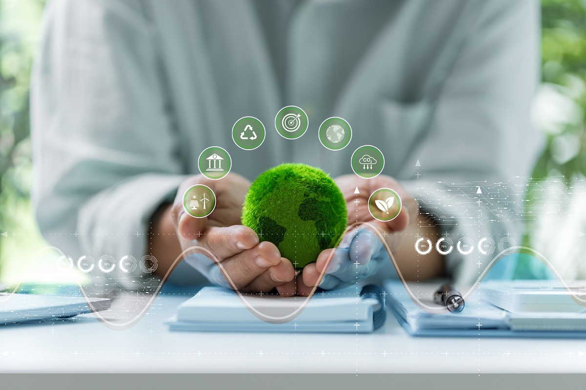 Hands holding a green globe symbolizing environmental compliance and sustainability in manufacturing operations