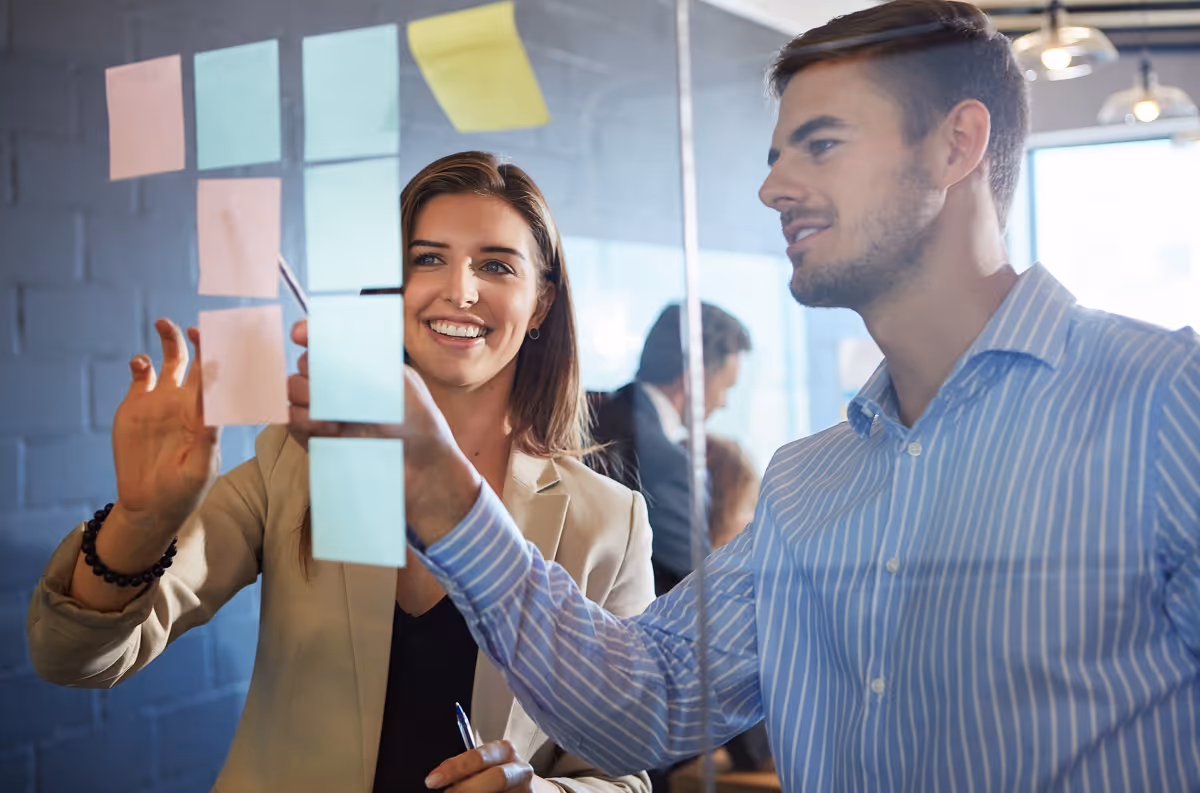 Business professionals planning strategy with sticky notes during due diligence analysis meeting