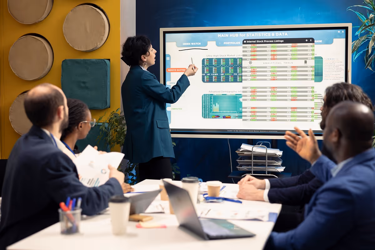Executives reviewing financial analytics and market data during an M&A target screening and valuation presentation.