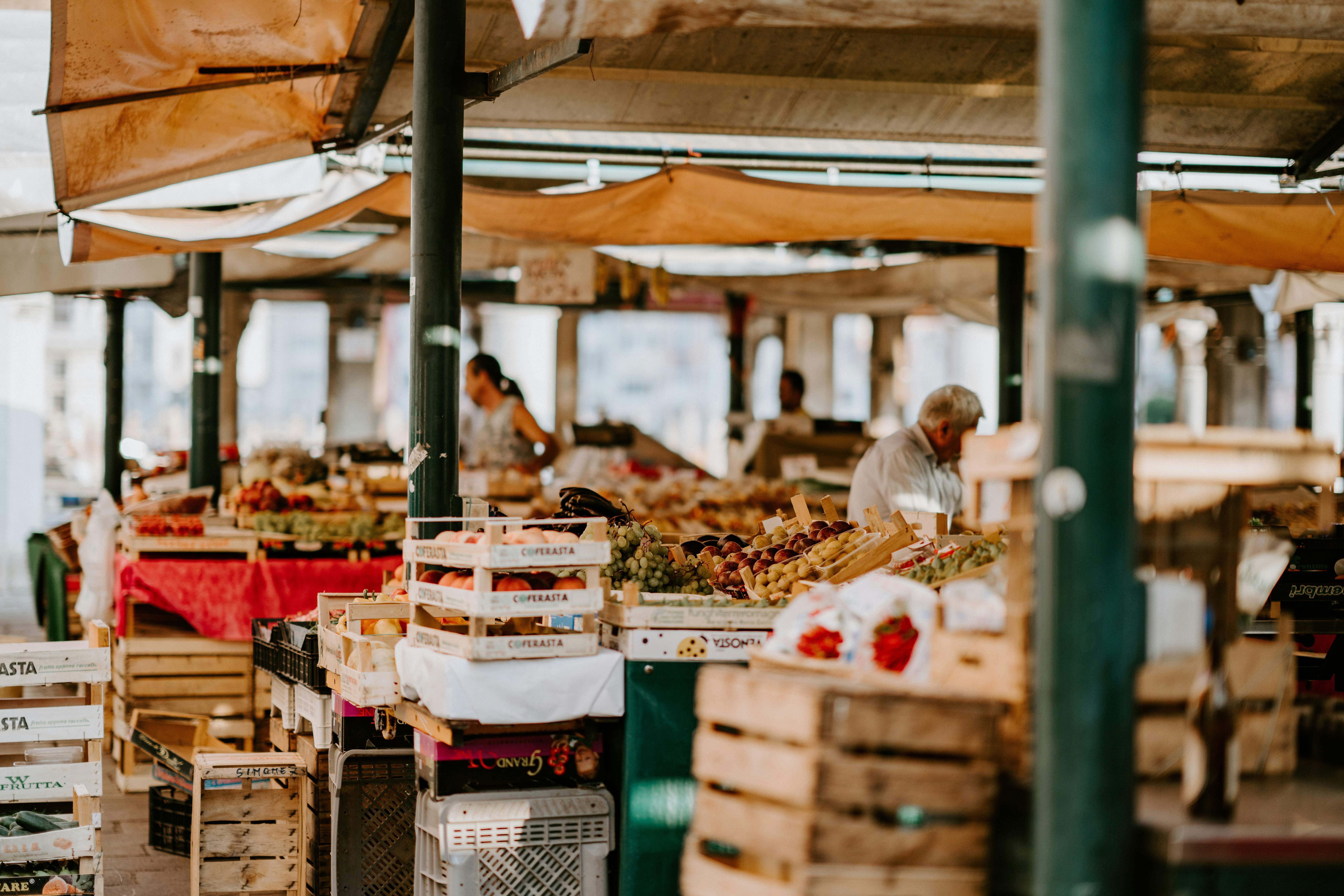 Colorful stalls at a traditional Italian outdoor market with fresh fruits and vegetables