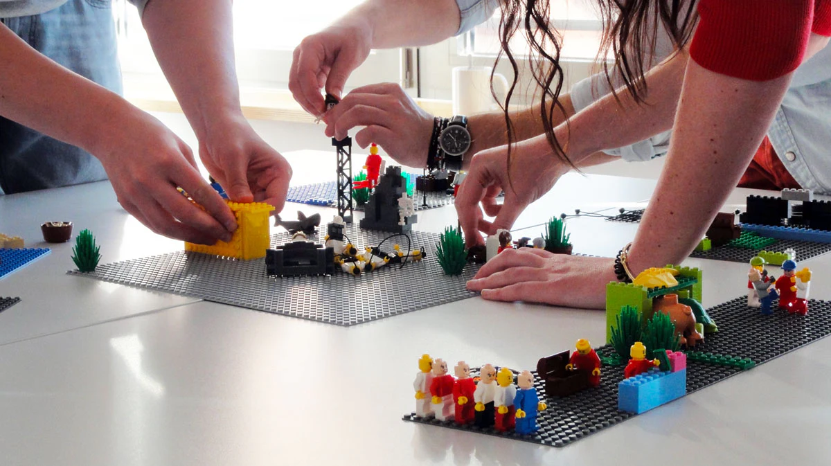 Participants construisant ensemble des maquettes en briques LEGO.