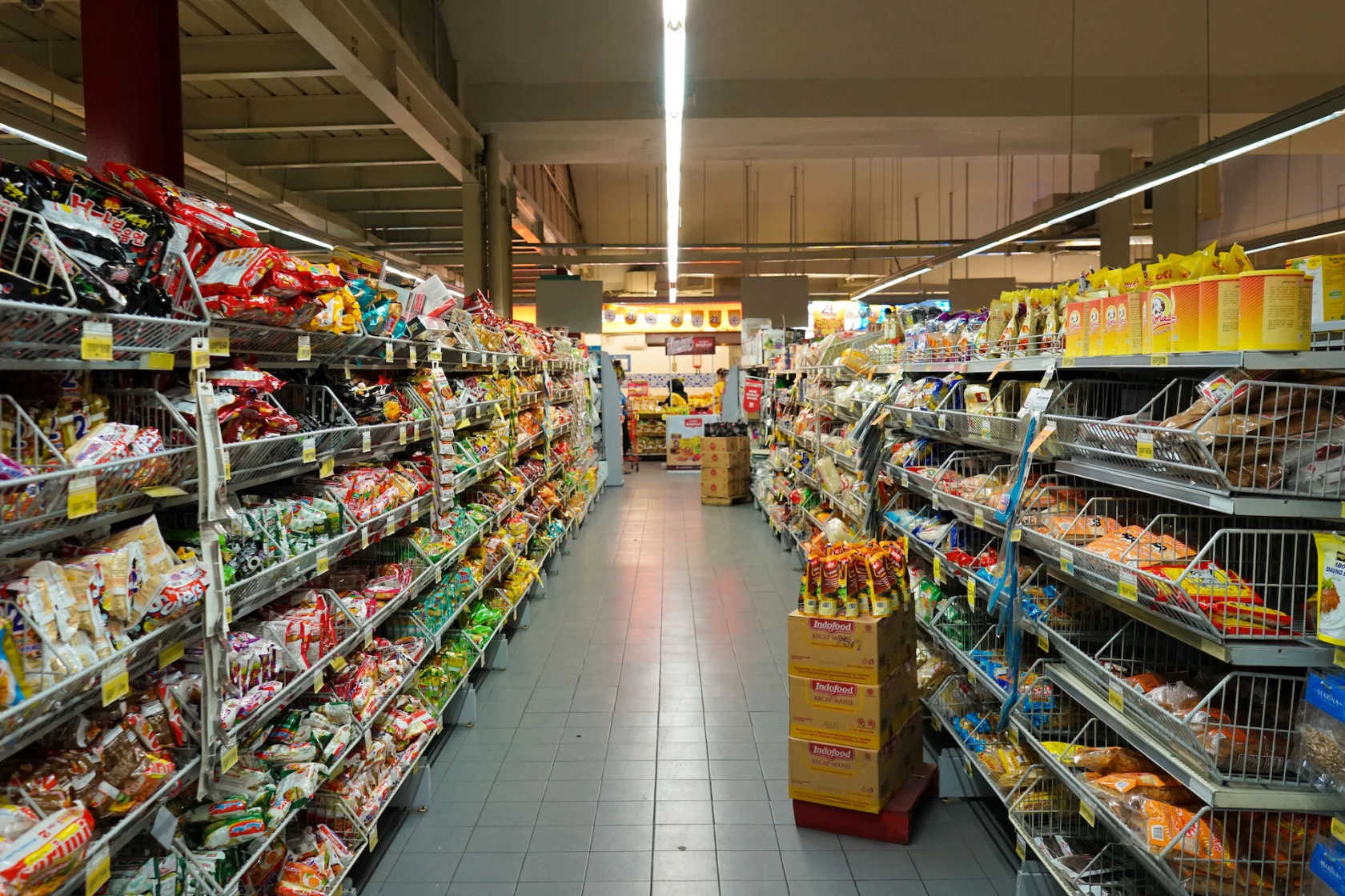 Allée de supermarché bordée de produits alimentaires.