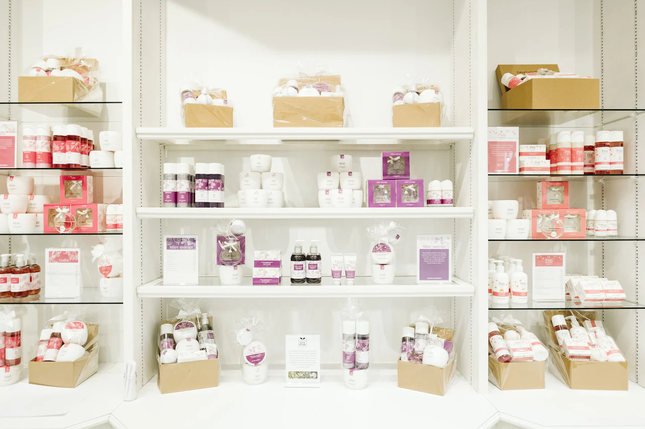 Étagères de boutique présentant des produits dans des emballages pastel.
