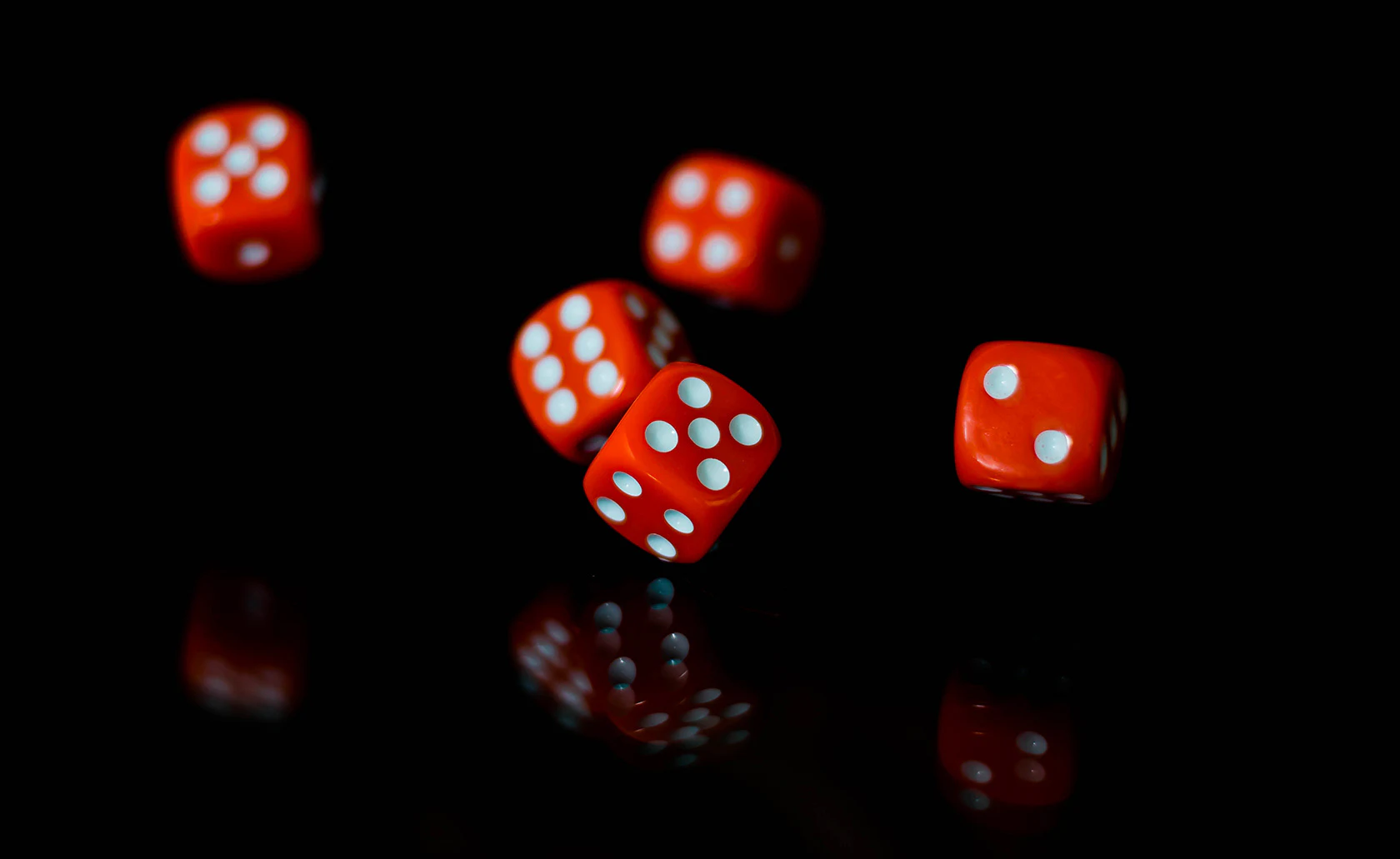 Dés rouges lancés sur un fond noir.