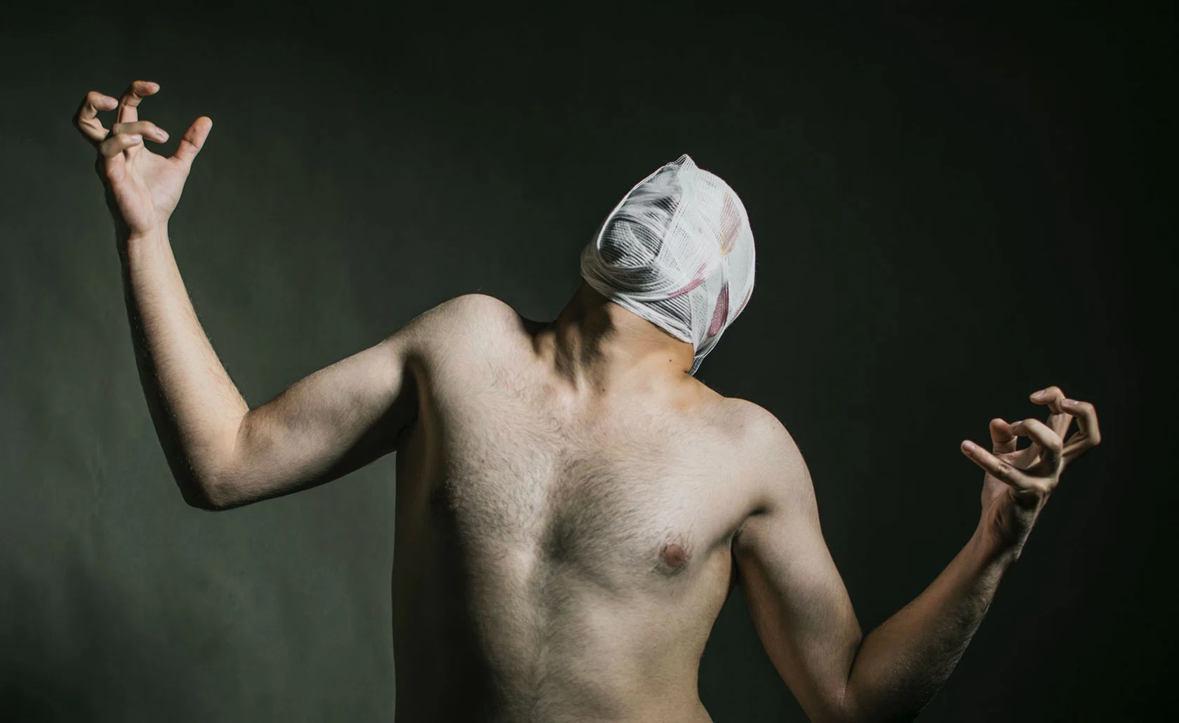 Homme torse nu, le visage recouvert d’un tissu.