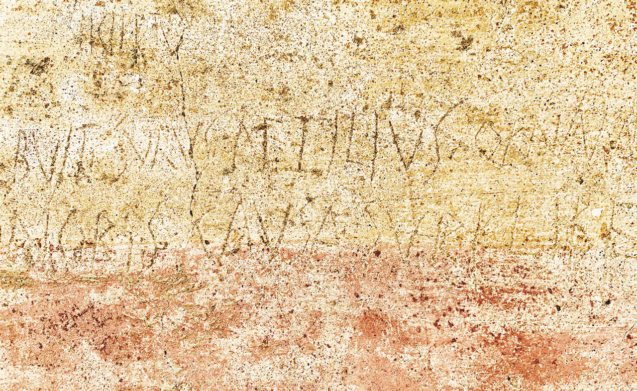 Inscriptions anciennes gravées sur un mur.