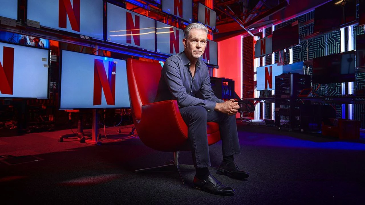 Homme assis dans un décor aux couleurs de Netflix.